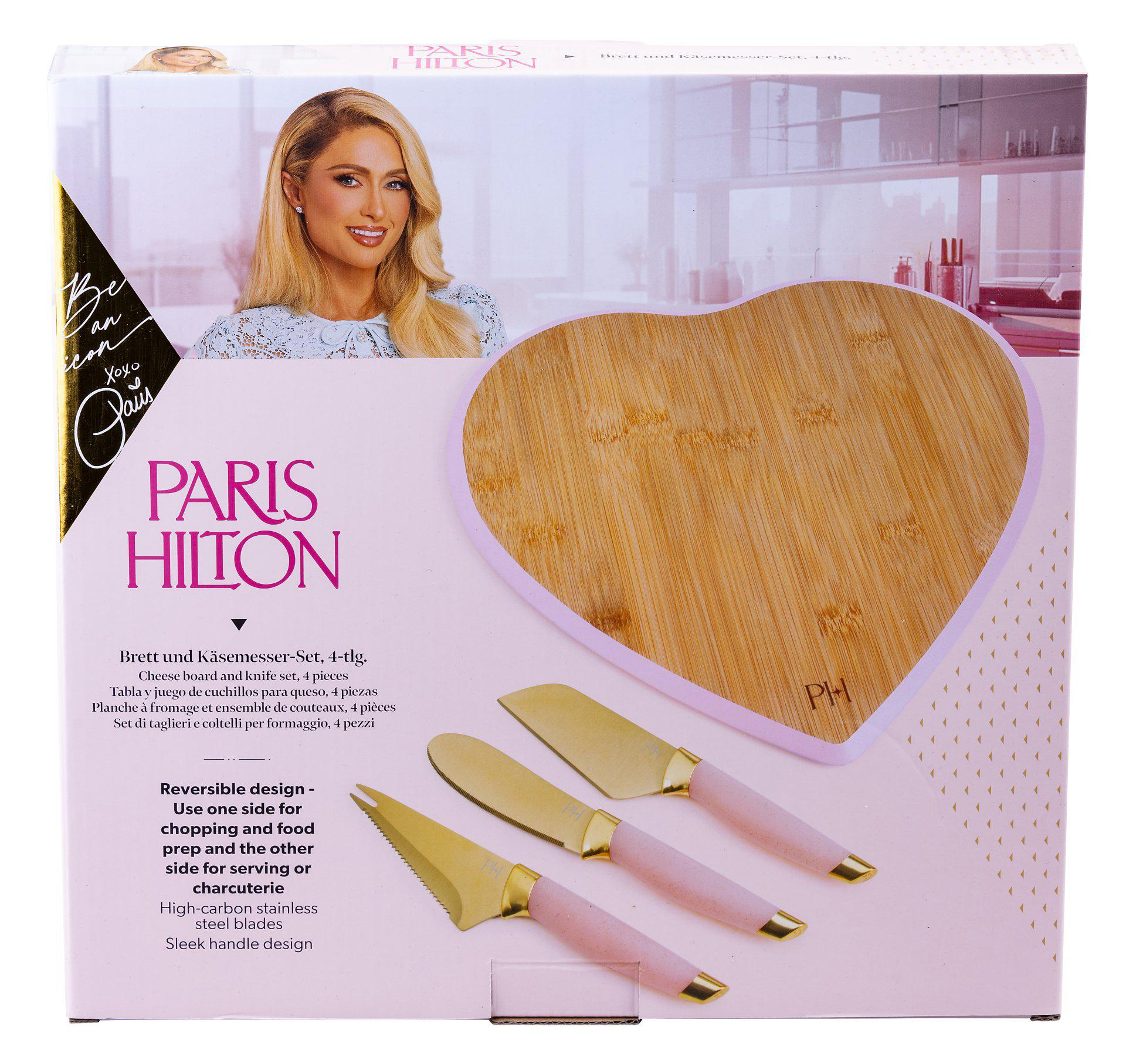 Paris Hilton Käsebrett-Set. Herzförmiges Brett und drei Messer auf rosa Box.