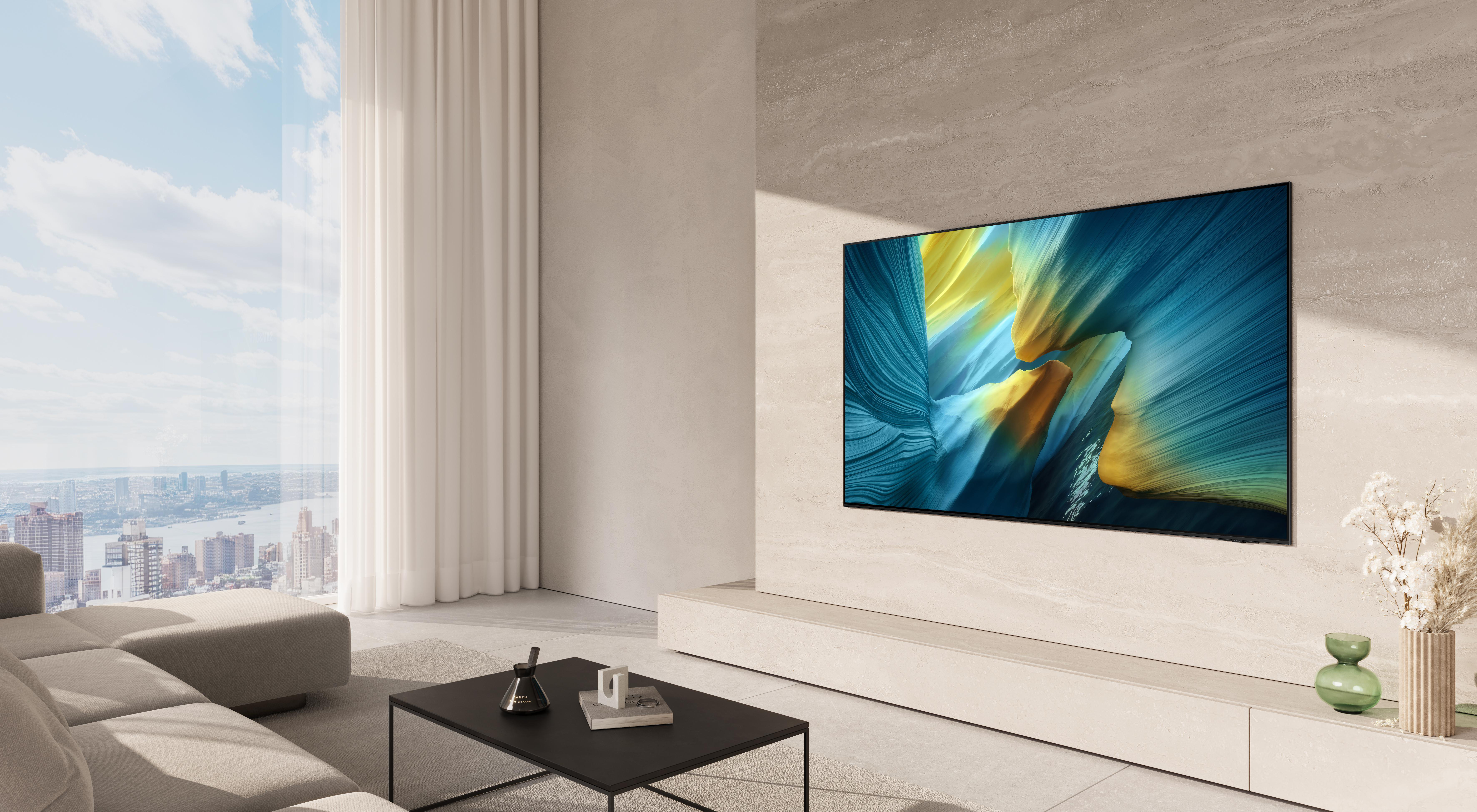 Wohnzimmer mit großem Fernseher, der abstrakte Kunst zeigt. Sofa, Couchtisch und Stadtblick durch ein Fenster sind sichtbar.