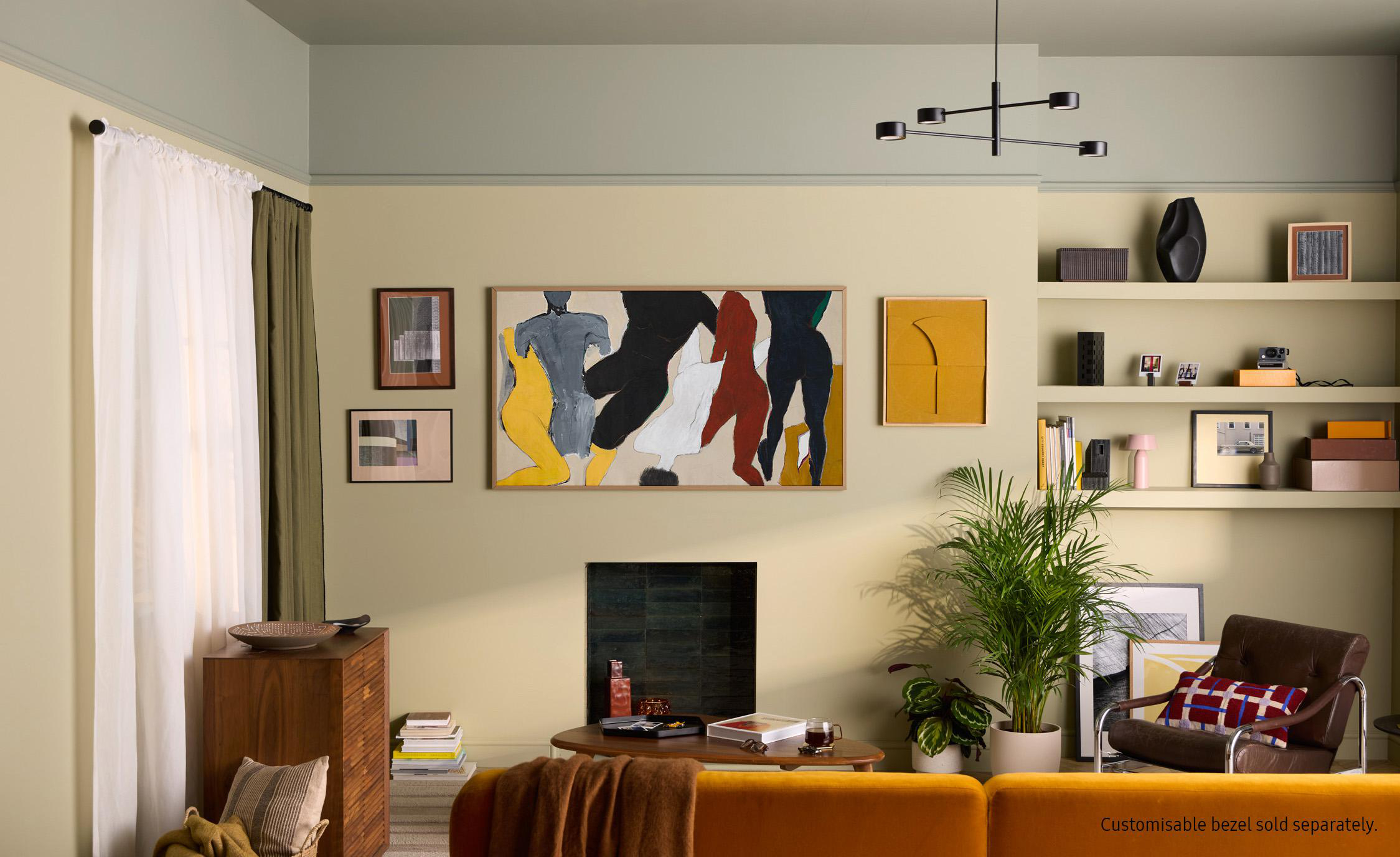 Wohnzimmer mit Kunst, Sofa, Stuhl und Pflanzen. Ein großes Gemälde hängt über einem Kamin. Stilvoll und modern.