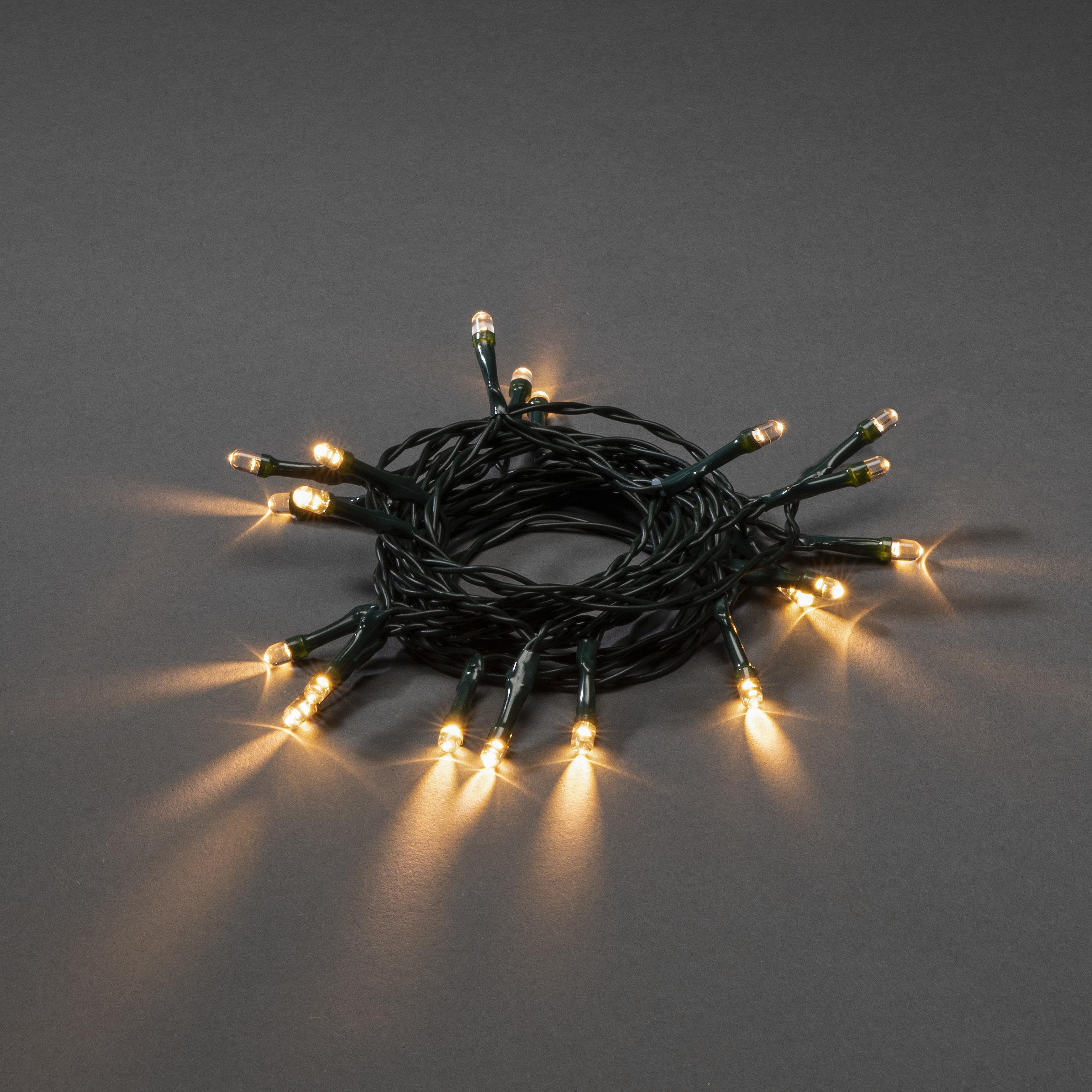 Eine Schnur mit LED-Leuchten, die sich auf einer grauen Oberfläche windet. Die Lichter leuchten.