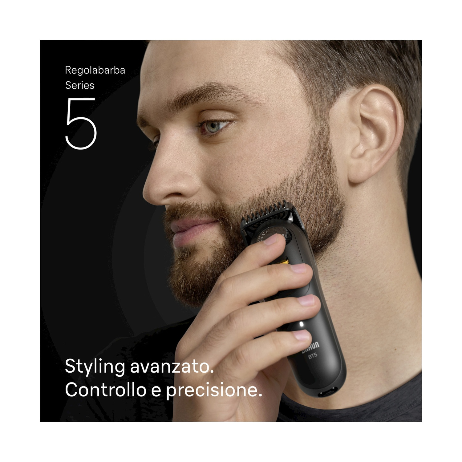 Un uomo si rade la barba con un trimmer nero. Il trimmer è tenuto vicino al viso. Lo sfondo è scuro.