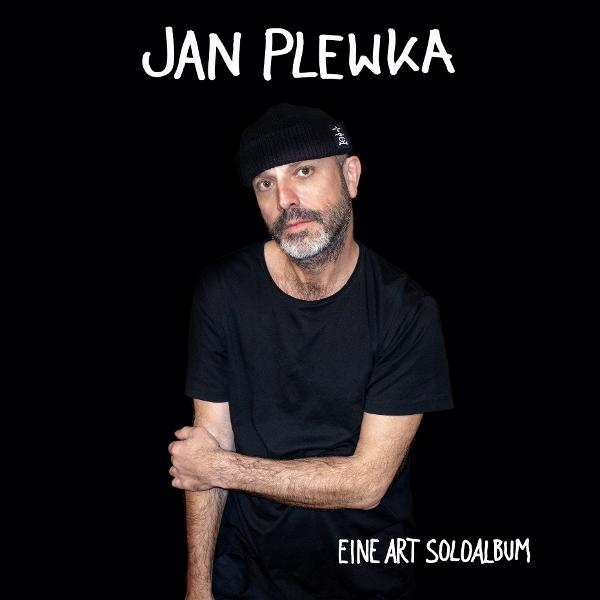 Mann mit schwarzer Mütze und Hemd. Der Text oben lautet "JAN PLEWKA". Der Text unten lautet "EINE ART SOLOLALBUM".
