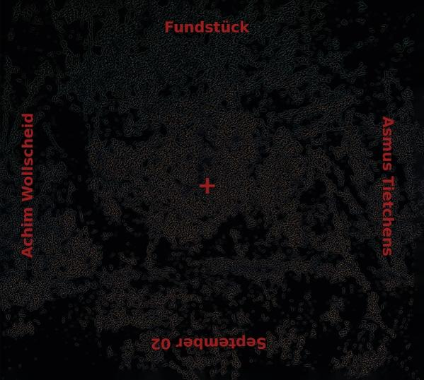 Dunkles Bild mit Text: Fundstuck, Achim Wollscheid, Asmus Tietchens, September 02 und ein rotes Kreuz in der Mitte.