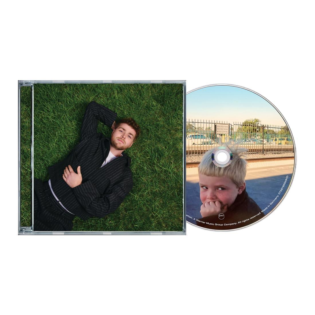 Eine CD-Hülle mit einem Mann, der auf Gras liegt. Die CD zeigt ein Kind auf einem Bahnsteig.