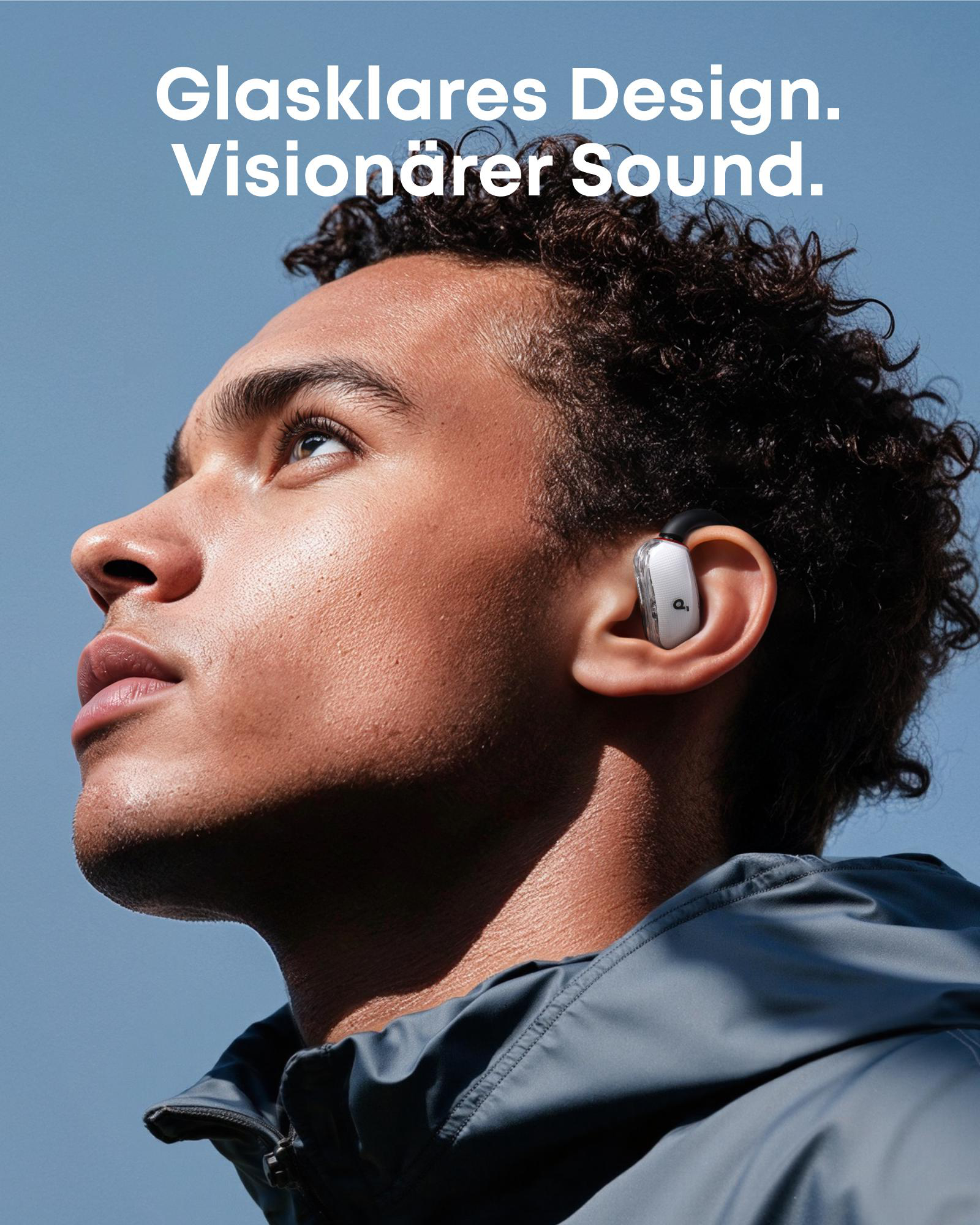 Ein Mann blickt nach oben und trägt einen Ohrhörer. Text oben: Glasklares Design. Visionärer Sound.