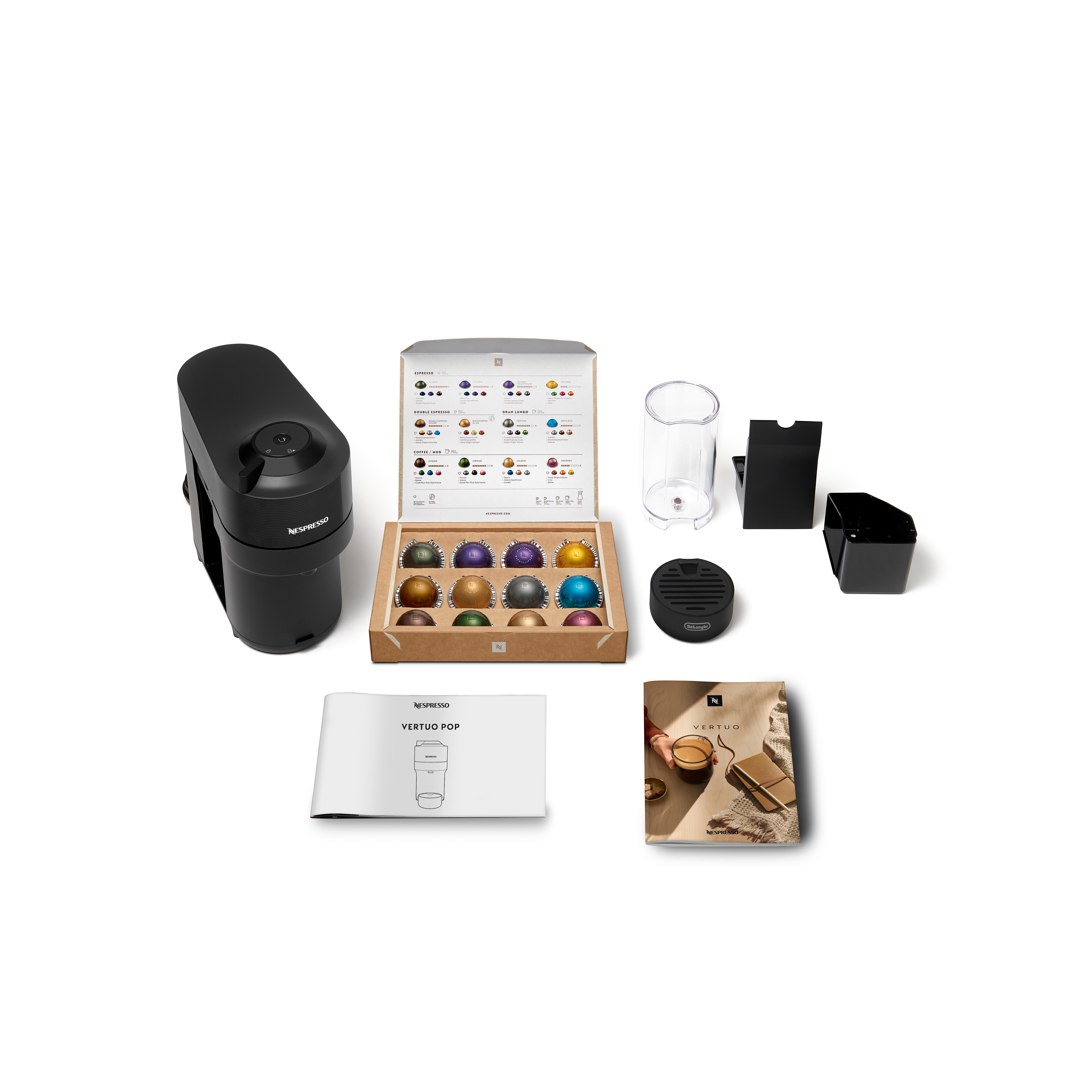 Schwarze Nespresso-Maschine mit Kapseln, Zubehör und Handbüchern, auf weißem Untergrund angeordnet.