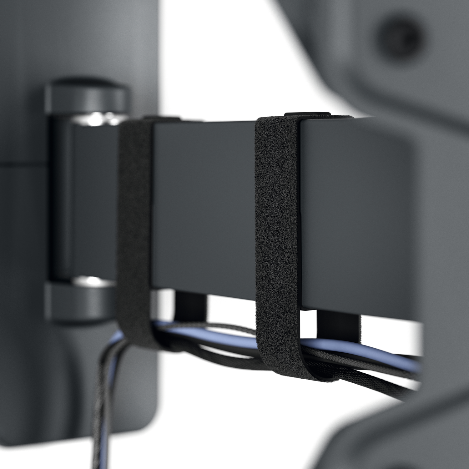 Close-up van een zwart kabelmanagementsysteem. Klittenband houdt de kabels vast. Zwarte en blauwe kabels zijn zichtbaar.