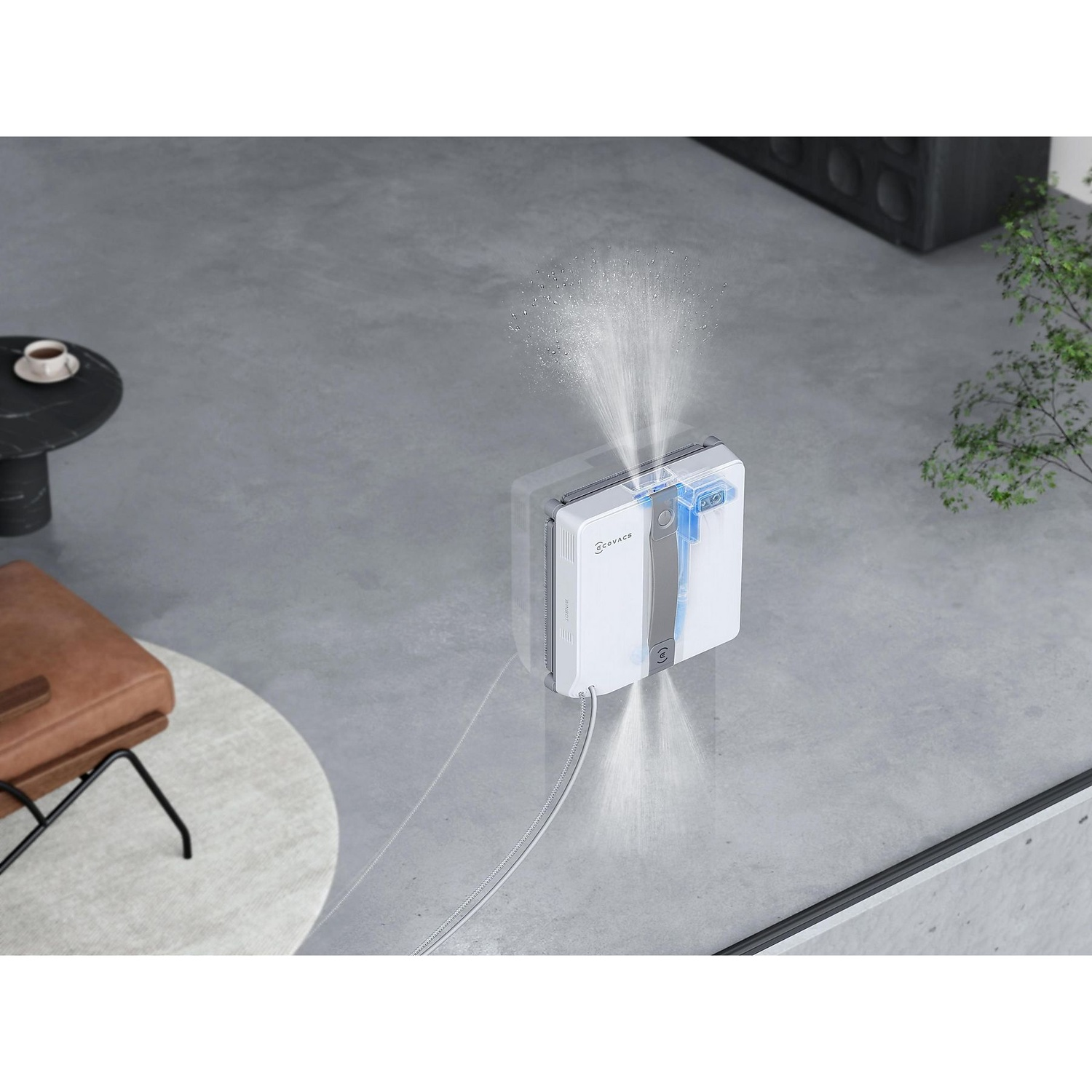 A white window cleaner sprays water. A table with a cup, a chair, a plant, and a gray floor are in the background.