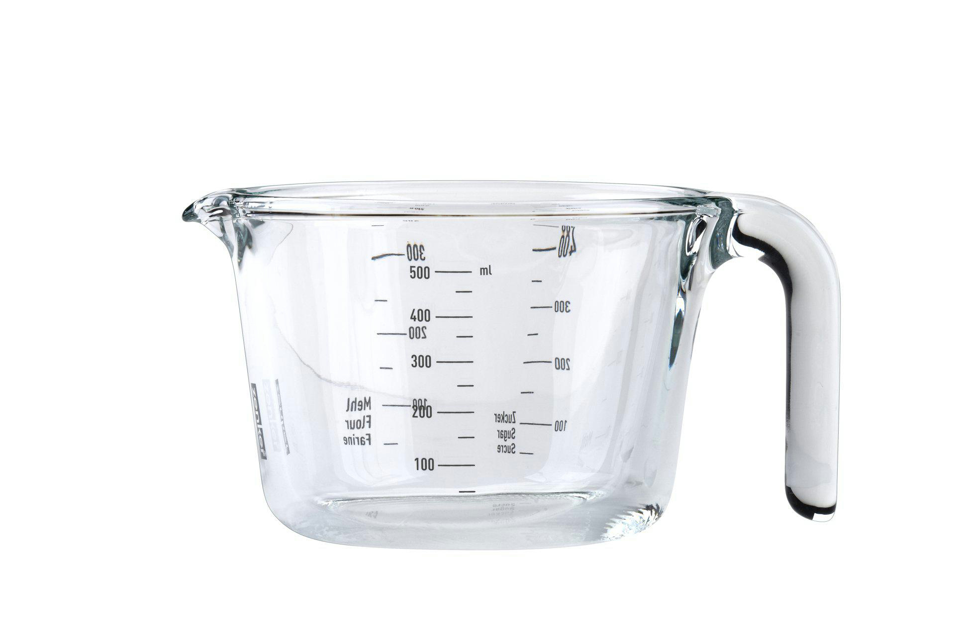 Ein Messbecher aus klarem Glas mit Griff. Es hat schwarze Volumenmarkierungen und steht vor weißem Hintergrund.