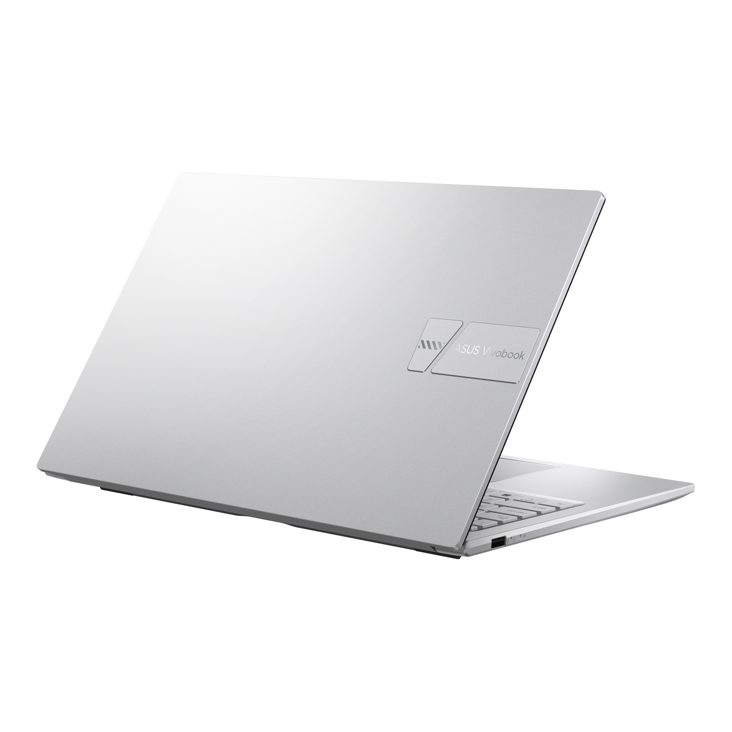 Un portátil ASUS Vivobook plateado está ligeramente abierto sobre un fondo blanco. El logotipo del portátil es visible.