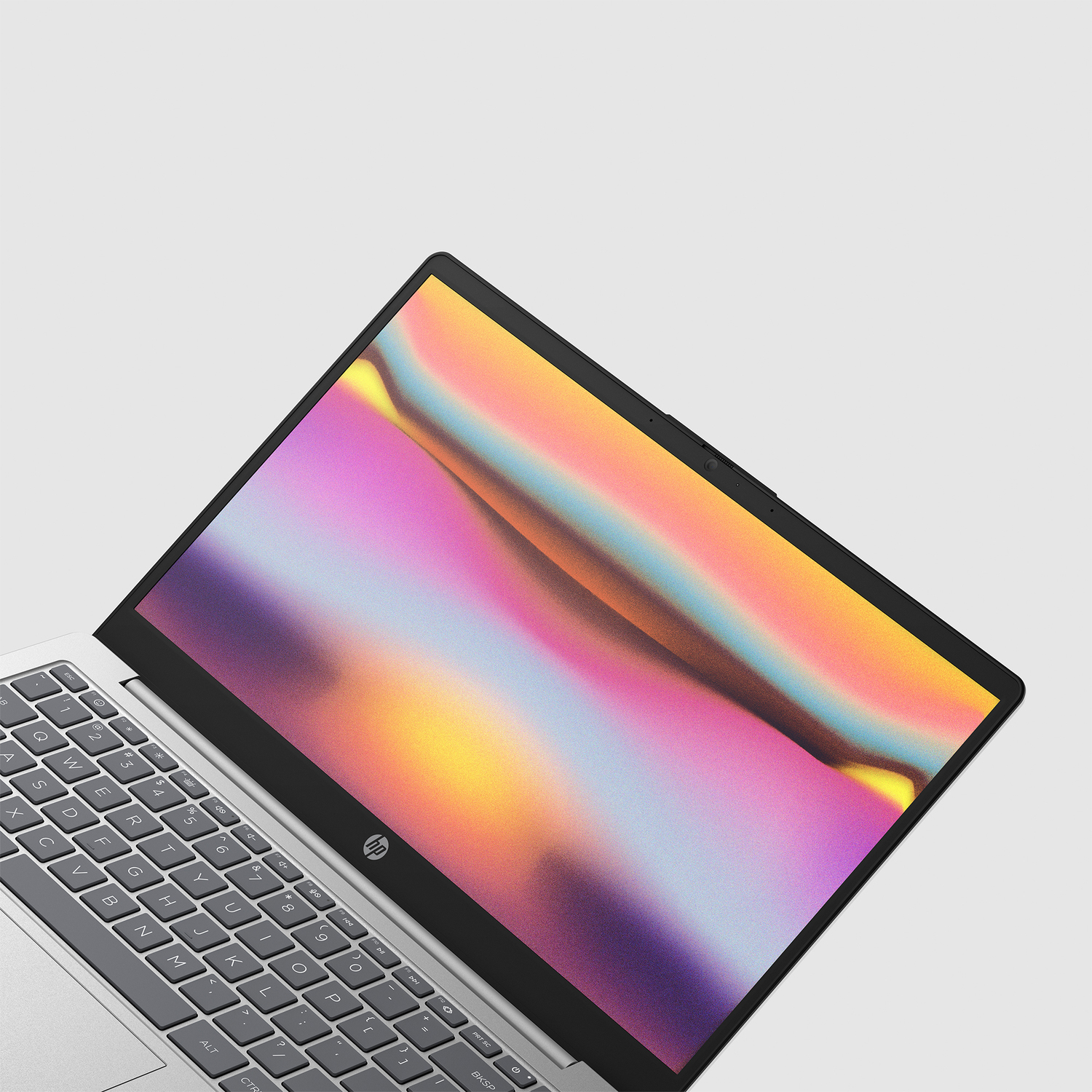 Laptop on white surface. Screen displays abstract colorful art. Keyboard visible, with HP logo. Angled view.