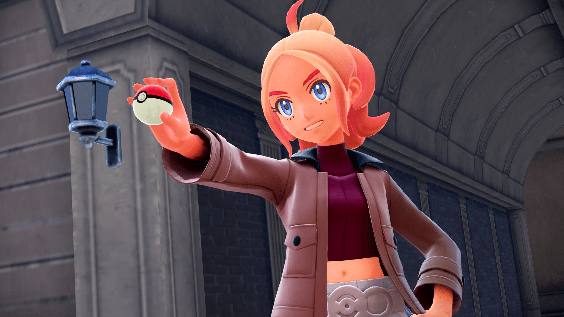 Eine Frau mit orangefarbenem Haar hält einen Pokéball. Sie trägt eine braune Jacke, ein rotes Hemd und einen weißen Rock vor einem Gebäude.