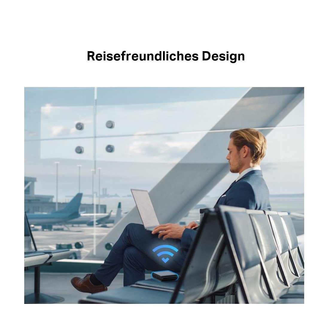 Ein Mann im Anzug benutzt einen Laptop am Flughafen. Ein Gerät mit WLAN-Symbol ist sichtbar. Flugzeuge sind draußen zu sehen.