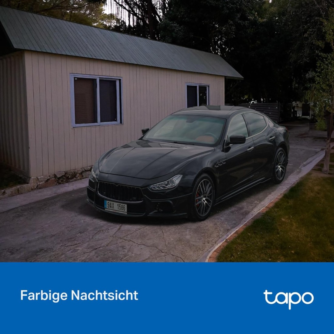 Schwarzer Maserati parkt vor einem hellen Gebäude. Das Auto steht auf einer Betonauffahrt mit Gras daneben.