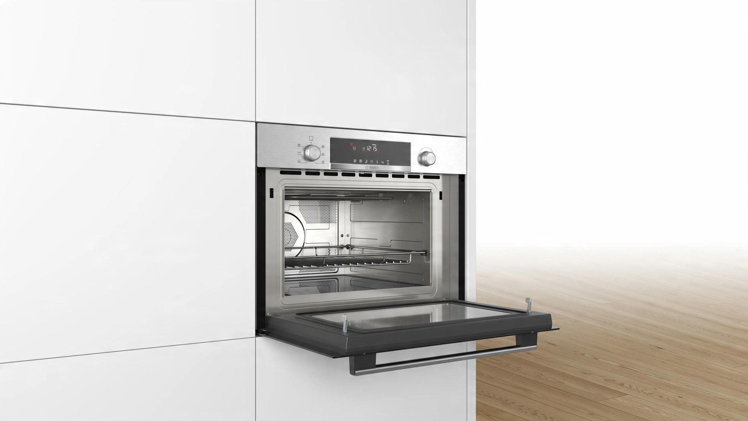 Piekarnik ze stali nierdzewnej jest otwarty, odsłaniając wewnętrzne półki. Znajduje się w białej szafce kuchennej. Drzwi są ciemnoszare.