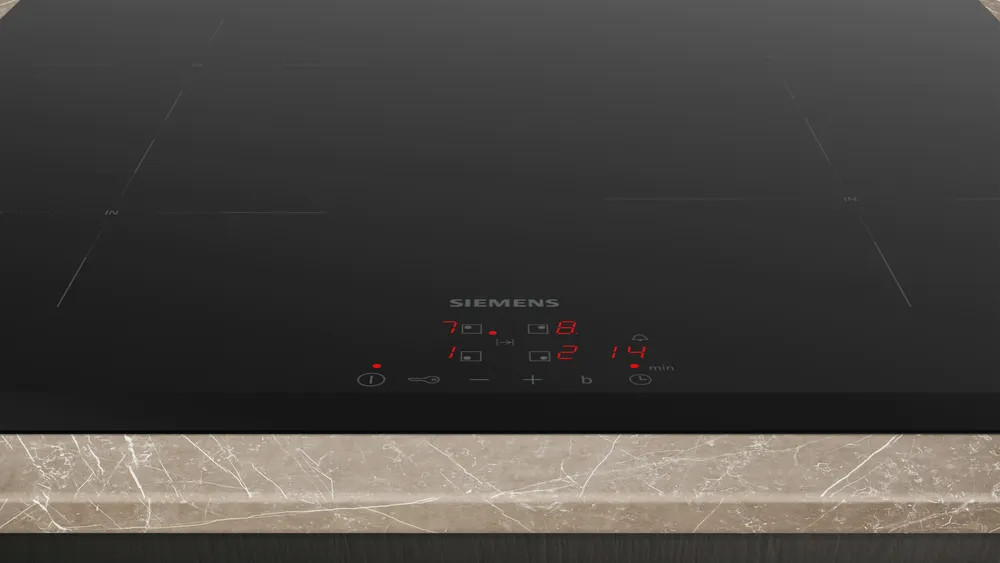Czarna płyta indukcyjna Siemens z wyświetlaczem cyfrowym. Blat ma wzór marmuru.