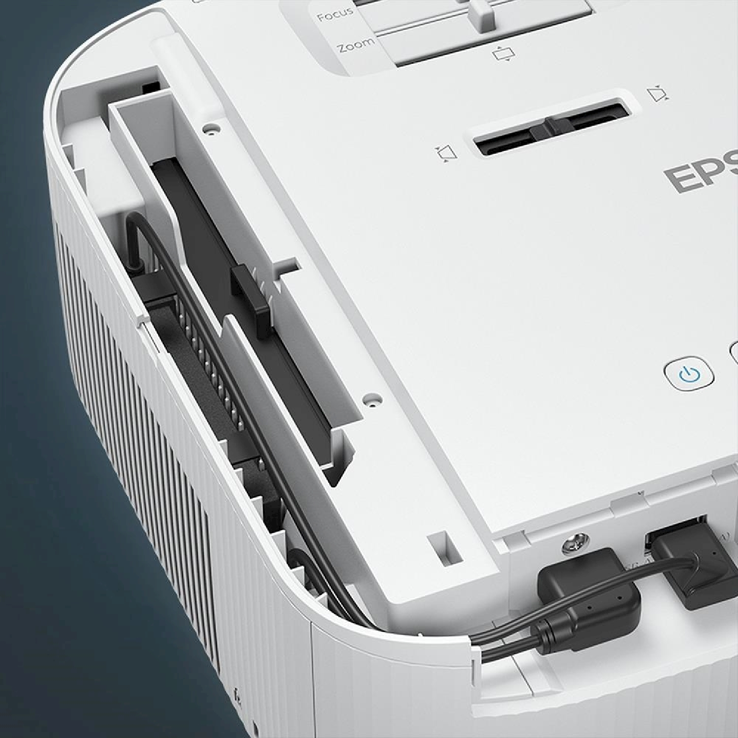 Proiettore bianco con cavi e porte neri. Controlli di messa a fuoco e zoom visibili. Logo Epson.