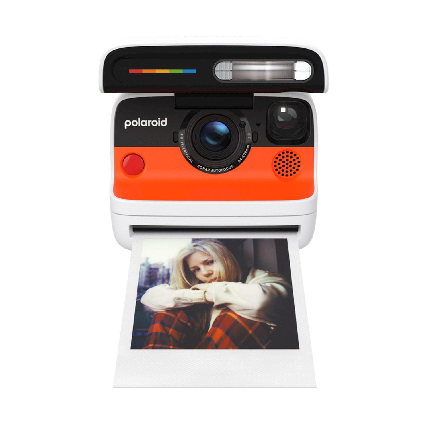 Una fotocamera Polaroid con corpo arancione e bianco stampa una foto di una donna con una camicia a quadri.