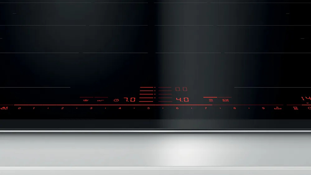 Czarna płyta indukcyjna z czerwonym wyświetlaczem cyfrowym. Biała powierzchnia poniżej.