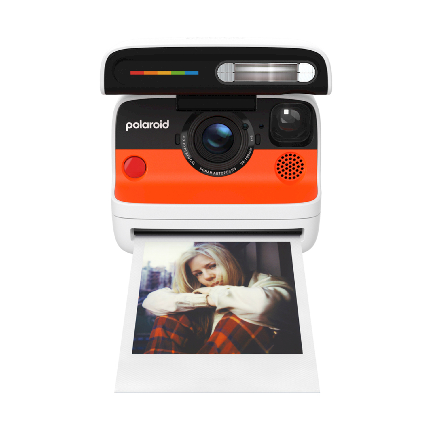 Una fotocamera Polaroid sta stampando una foto. La fotocamera è arancione e bianca. La foto mostra una giovane donna con i capelli biondi.