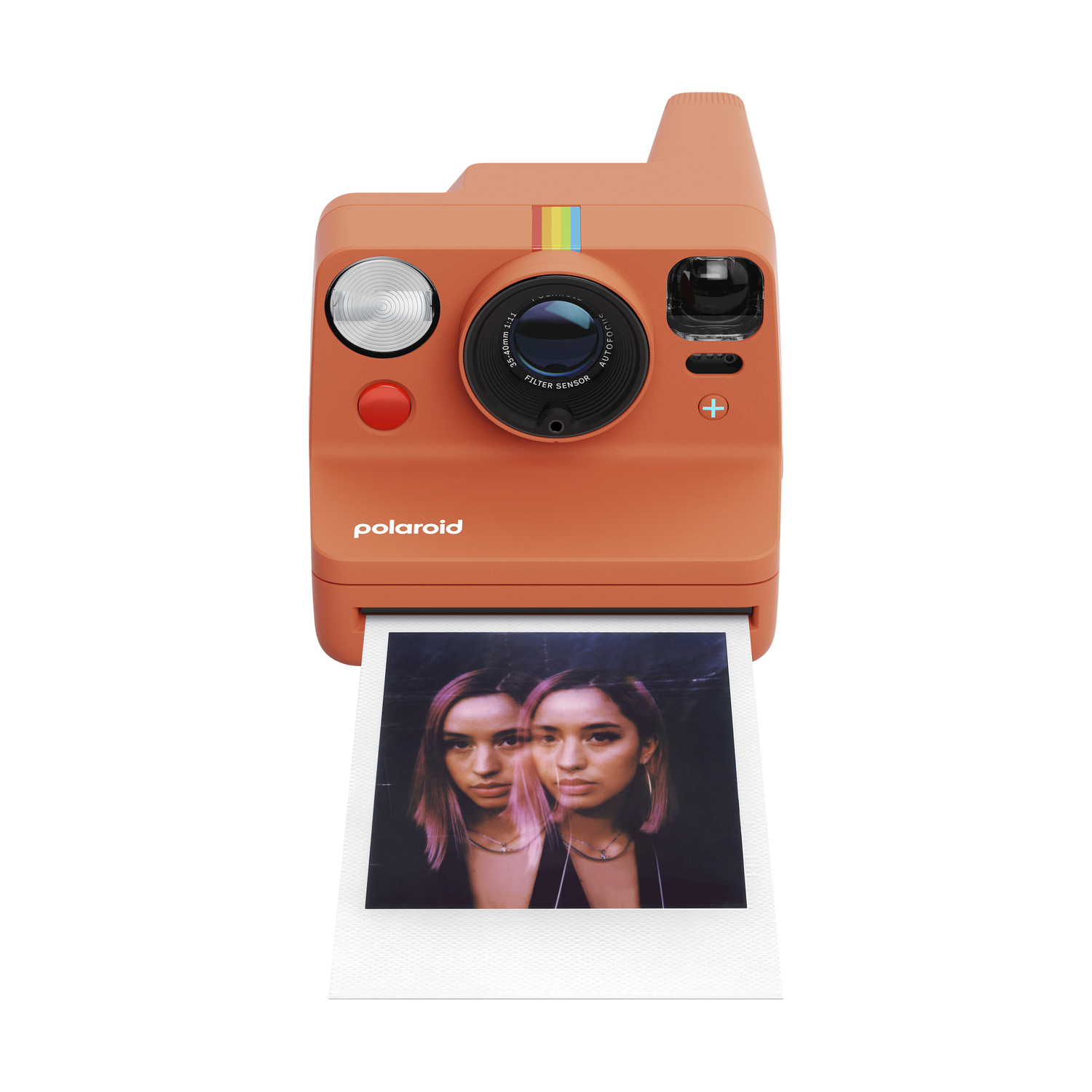 Fotocamera Polaroid arancione con foto di due donne. Dettagli: lente, flash, striscia arcobaleno. Foto in fase di sviluppo.