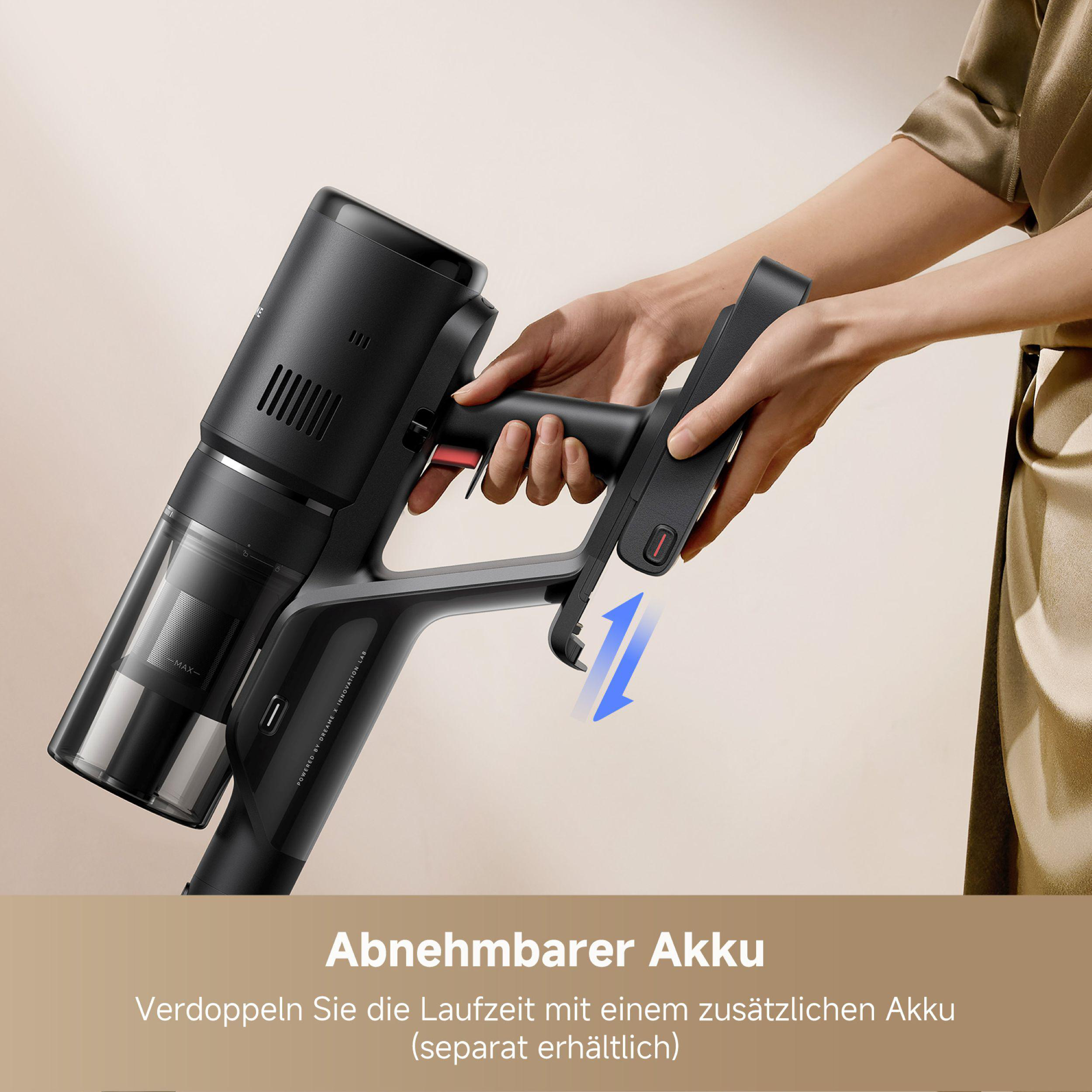 Ein schwarzer Staubsauger wird von einer Person von seiner Ladestation getrennt. Die Basis wird in der anderen Hand gehalten.