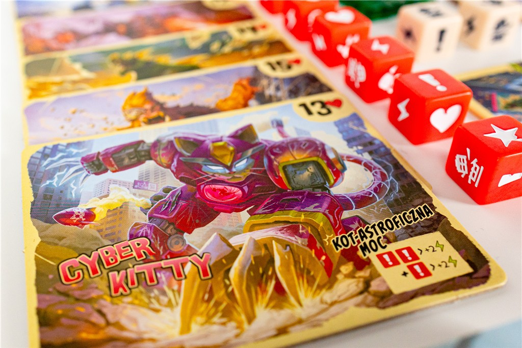 Karta do gry z postacią robota-kota. Czerwone kości z symbolami po prawej stronie. Widoczne są również inne karty i kości.