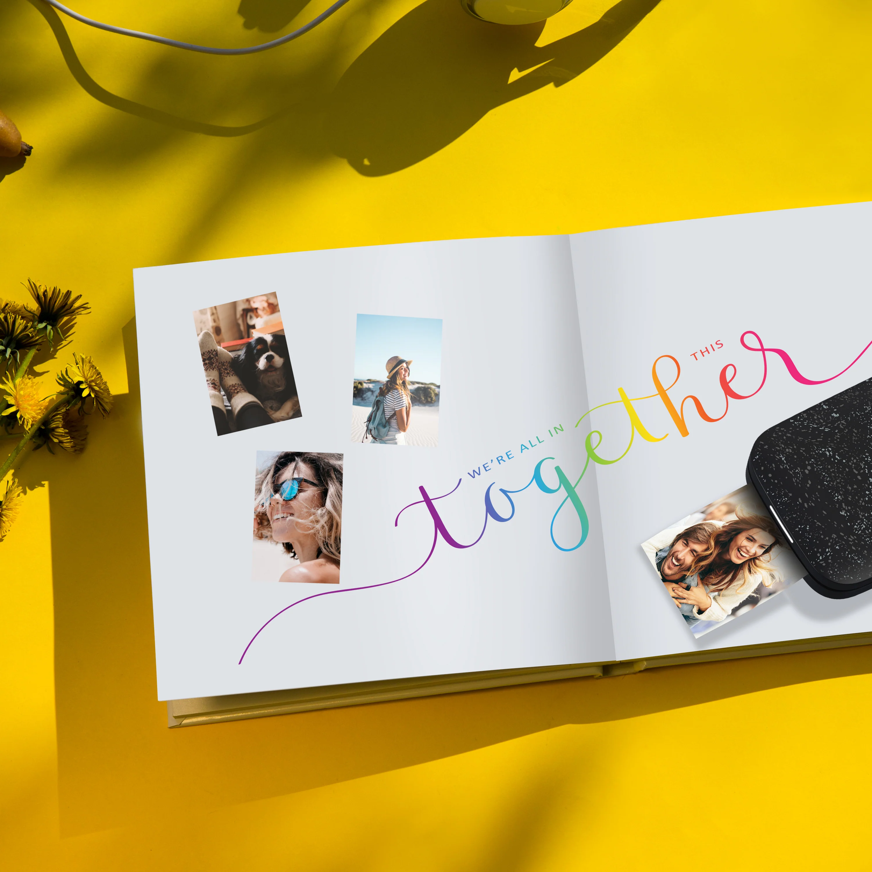 Egy nyitott könyv fotókkal és a 'together' szóval. Egy telefon jobbra, sárga háttérrel.