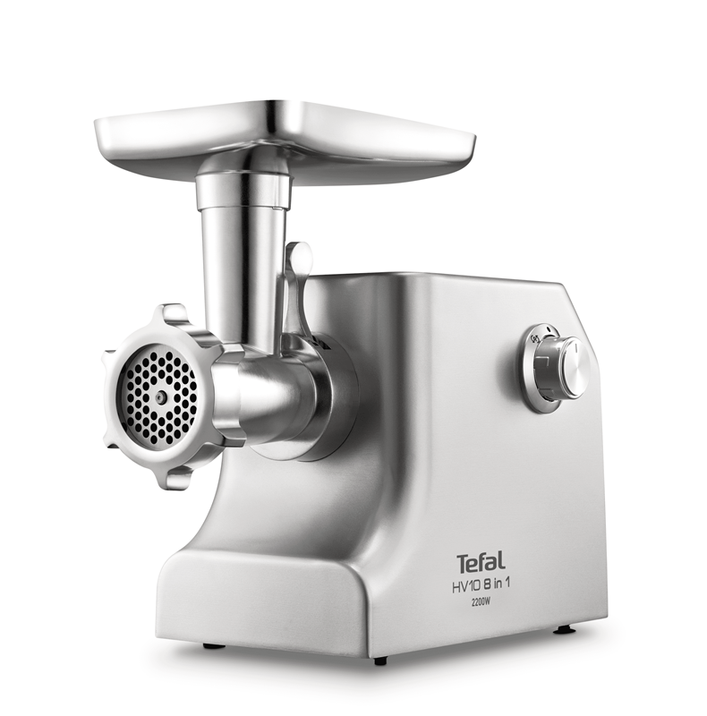 Egy ezüst Tefal húsdaráló. Van egy adagolótálcája, darálófeje és egy vezérlőgombja. A címke azt írja: Tefal HV10 8 az 1-ben 2200W.