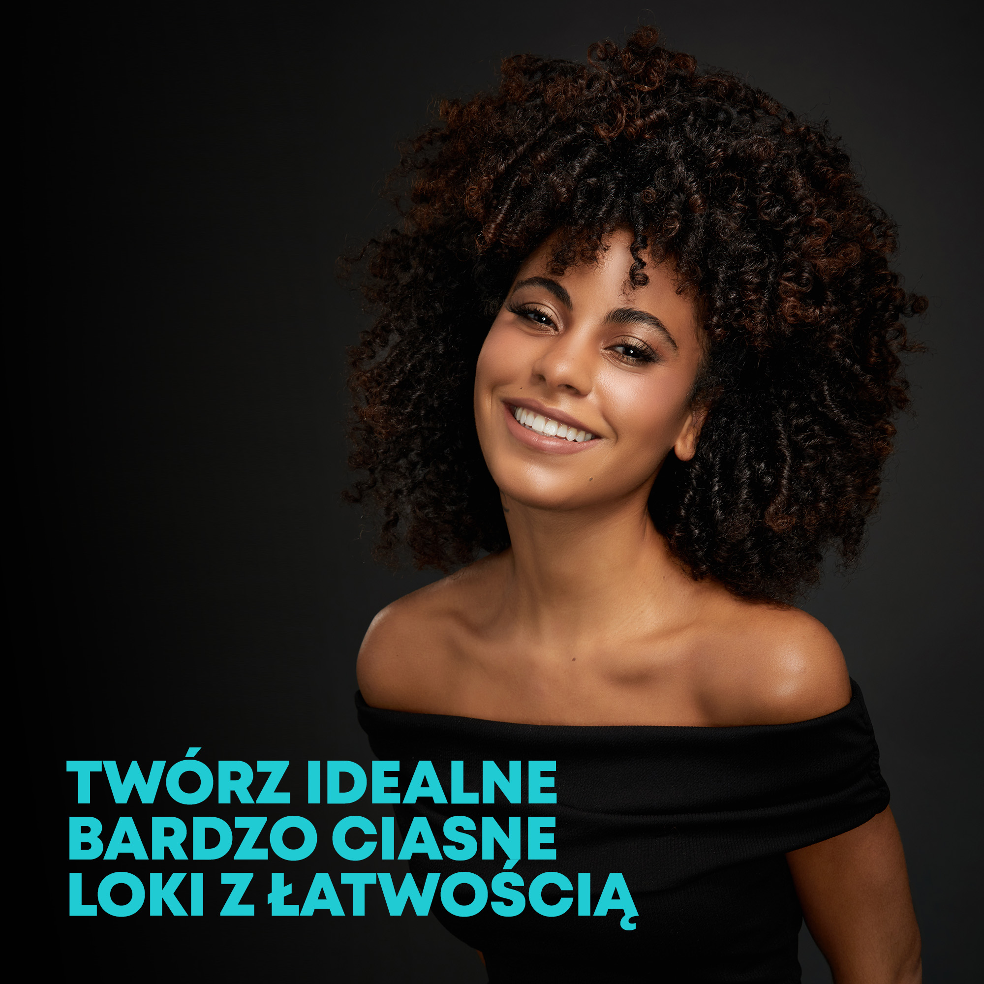 Kobieta z kręconymi brązowymi włosami uśmiecha się, ma na sobie czarny top. Tekst: Twórz idealne, ciasne loki z łatwością.