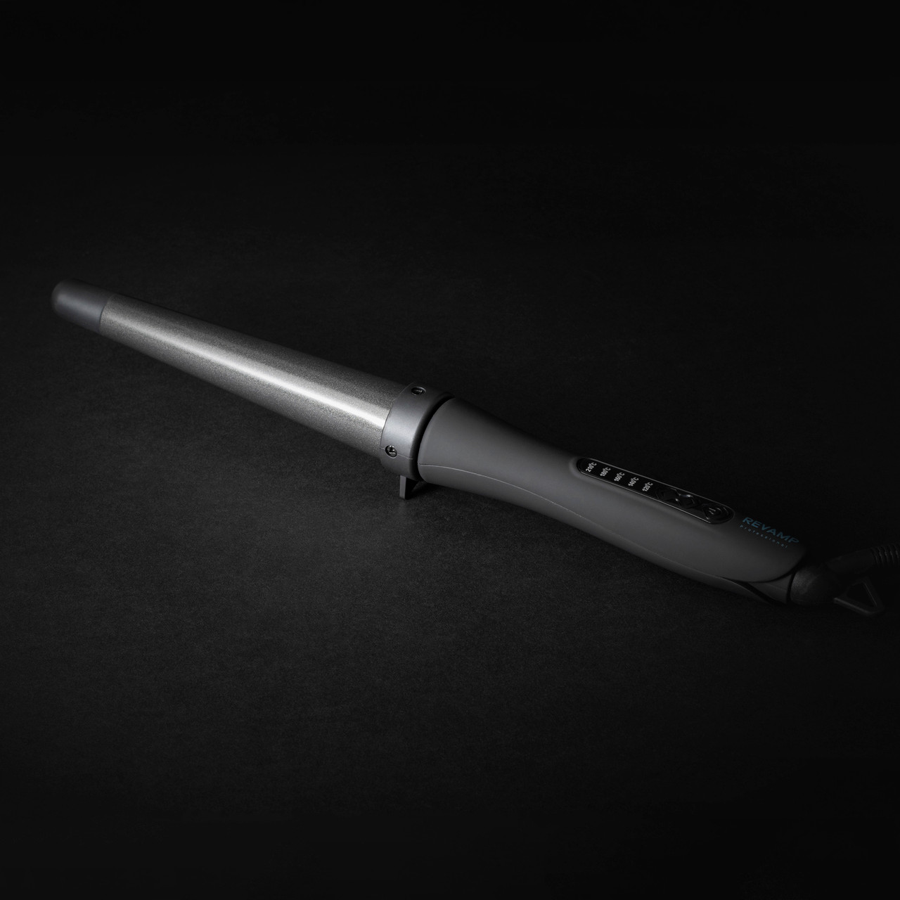 Lokówka Revamp leży na czarnej powierzchni. Jest szara i srebrna z ustawieniami temperatury.