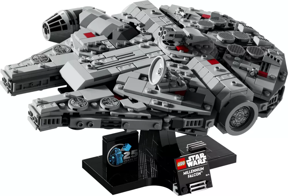 A Lego Millennium Falcon model, gray with red accents, rests on a black stand with a Star Wars logo and a 25th-anniversary emblem.