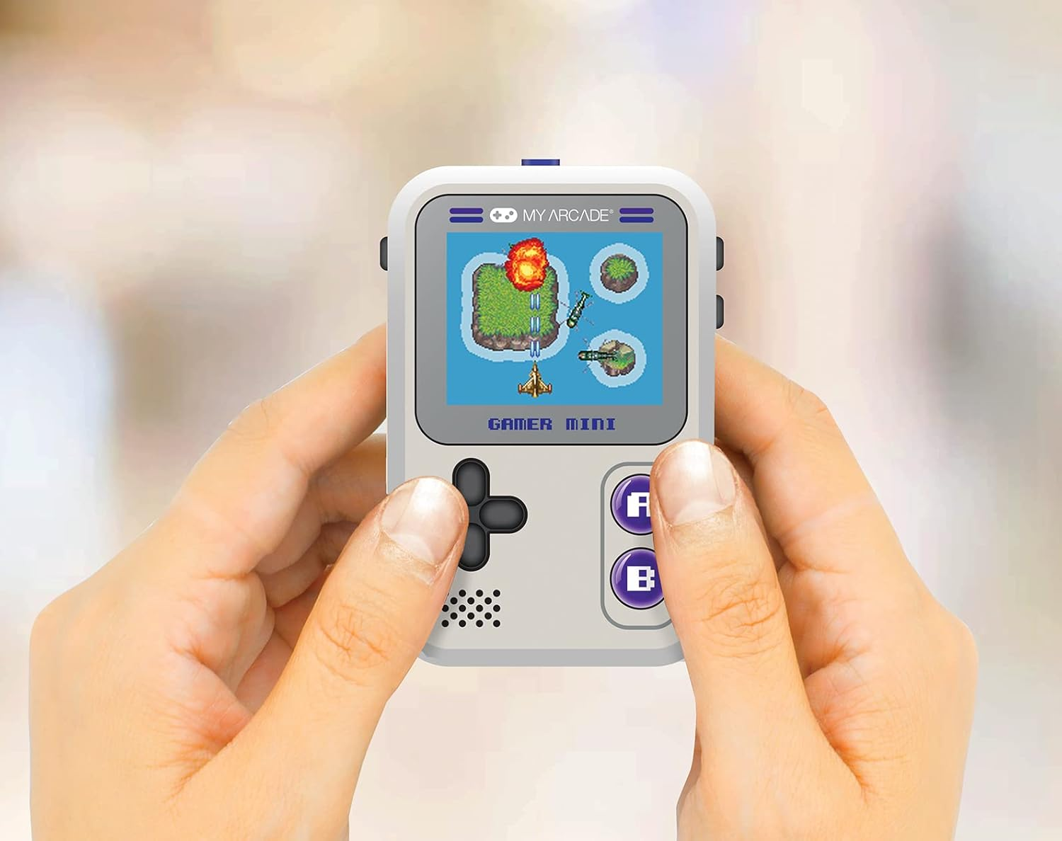 Des mains tiennent une console de jeu portable. L'écran affiche un jeu avec une mer bleue, des îles et un avion. Boutons visibles.
