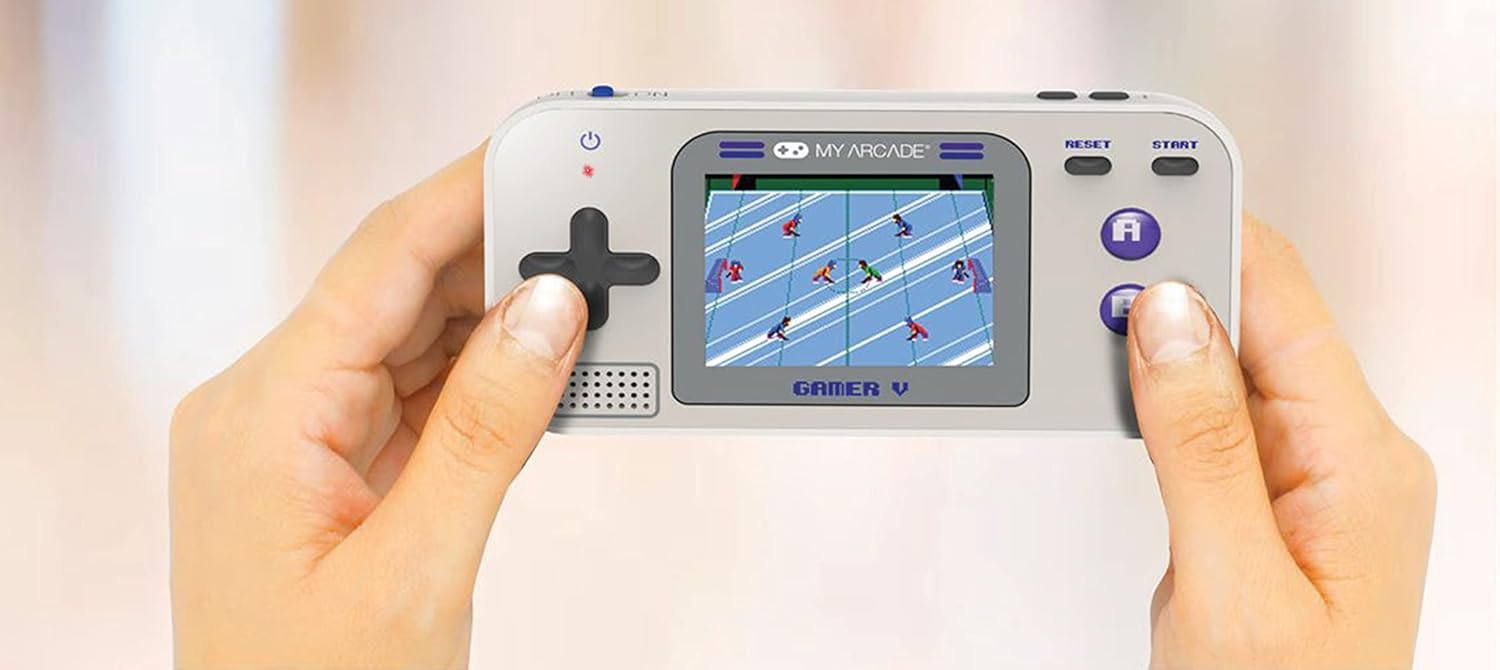 Mains tenant une console de jeu portable rétro. L'écran affiche un jeu de foot. Boutons visibles.
