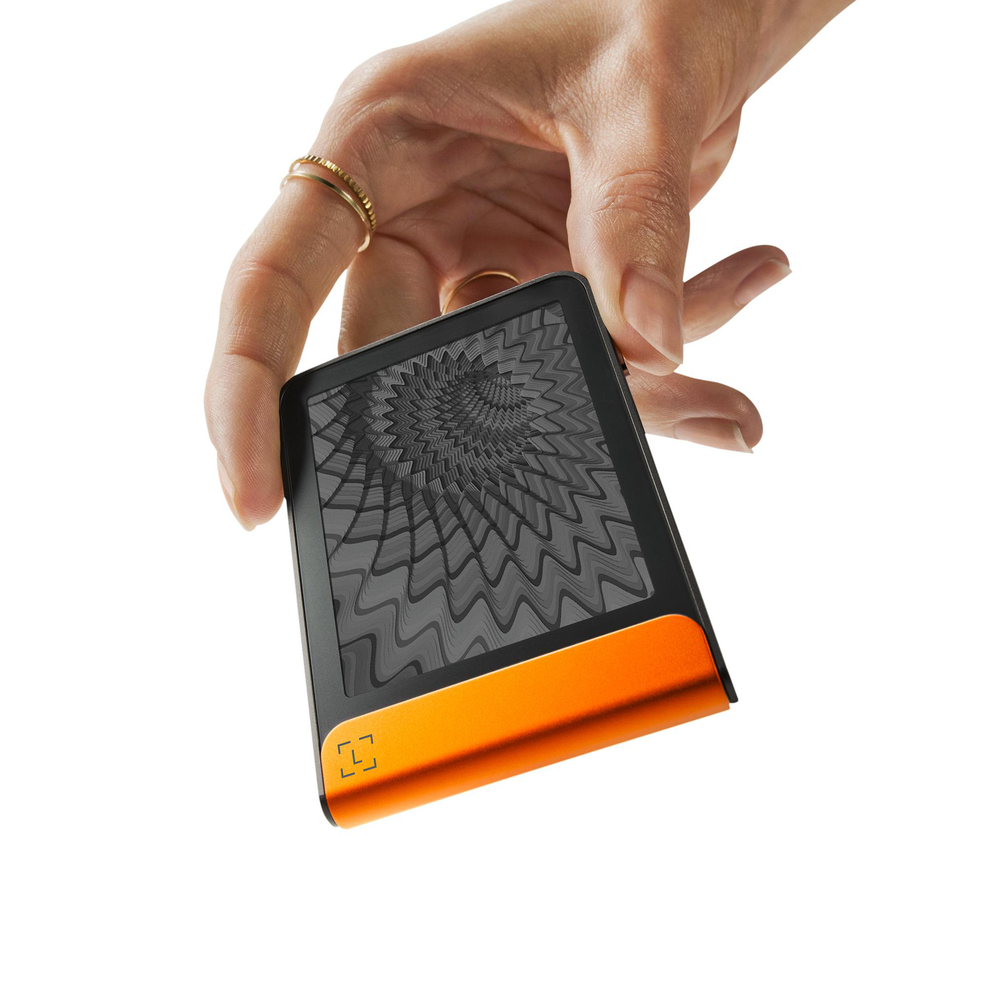 Eine Hand hält ein schwarz-oranges Gerät mit einem Bildschirm, der ein graues Spiralmuster zeigt.