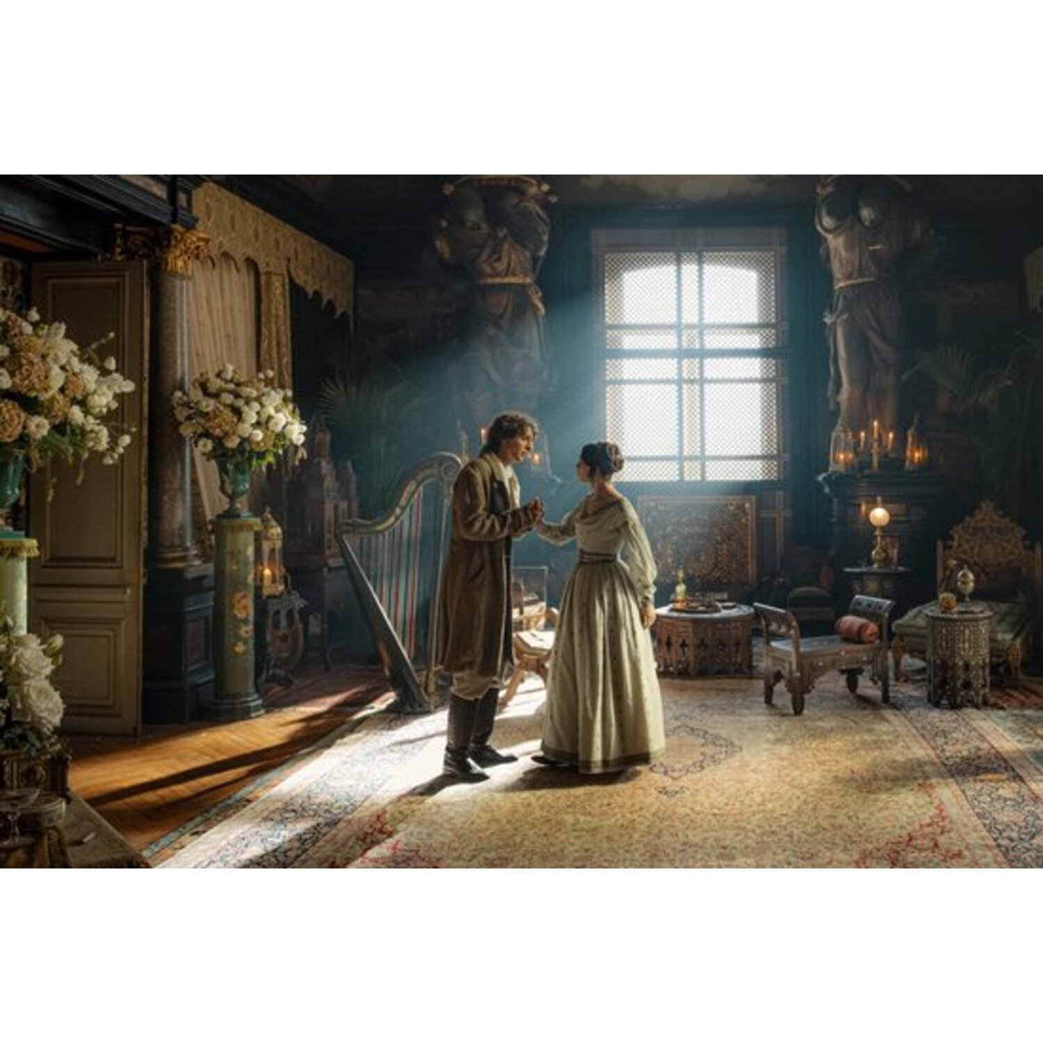 A man and woman in period clothing hold hands in a room with a harp, statues, and a large window. Sunlight streams in.