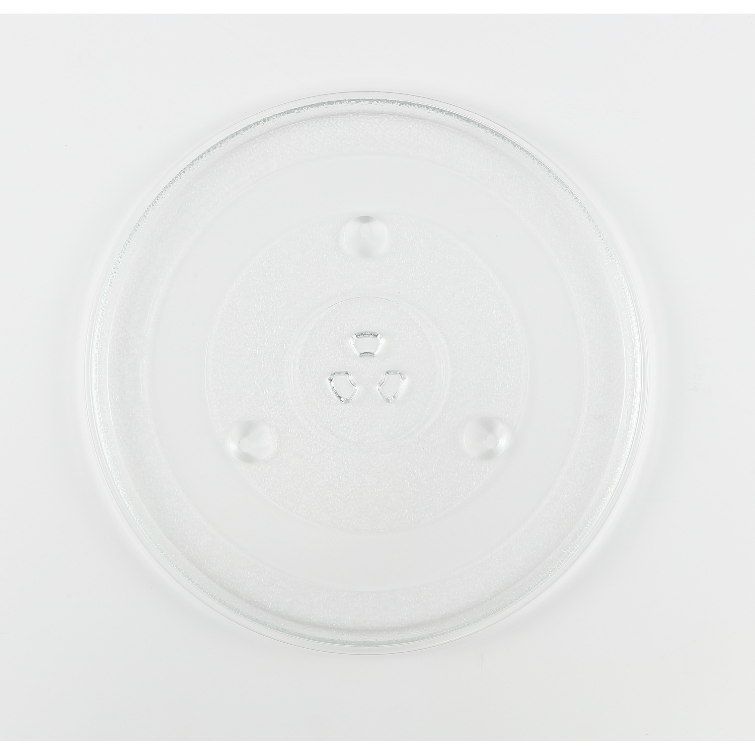 Een heldere, cirkelvormige glazen plaat, waarschijnlijk van een magnetron, met drie kleine bultjes en een centrale inkeping. Op een witte achtergrond.