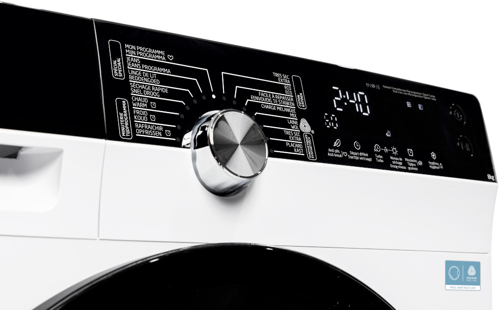 Washing machine control panel. Features include a dial, digital display, and various program options labeled in multiple languages.