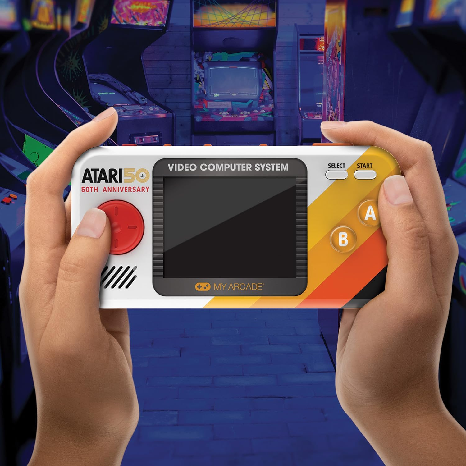 Mains tenant une console de jeux vidéo rétro. Elle a un écran, des boutons et le logo Atari 50e anniversaire, avec des jeux d'arcade en arrière-plan.