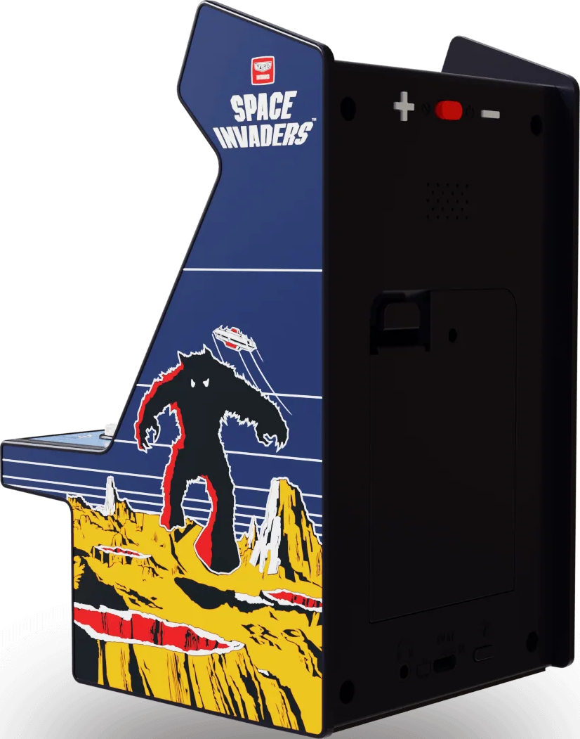 Mini-jeu d'arcade Space Invaders. Comprend un boîtier noir et un panneau bleu avec un monstre et un vaisseau spatial sur un paysage jaune.