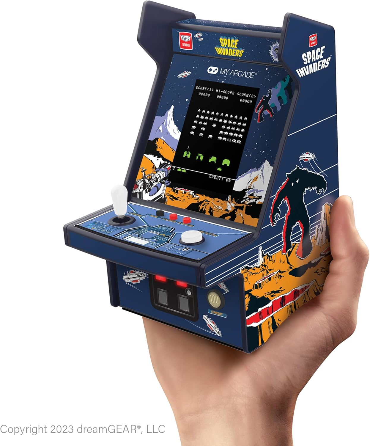 Main tenant un mini jeu d'arcade Space Invaders. Le jeu a un écran affichant le jeu et un joystick. Couleurs bleu foncé et orange.
