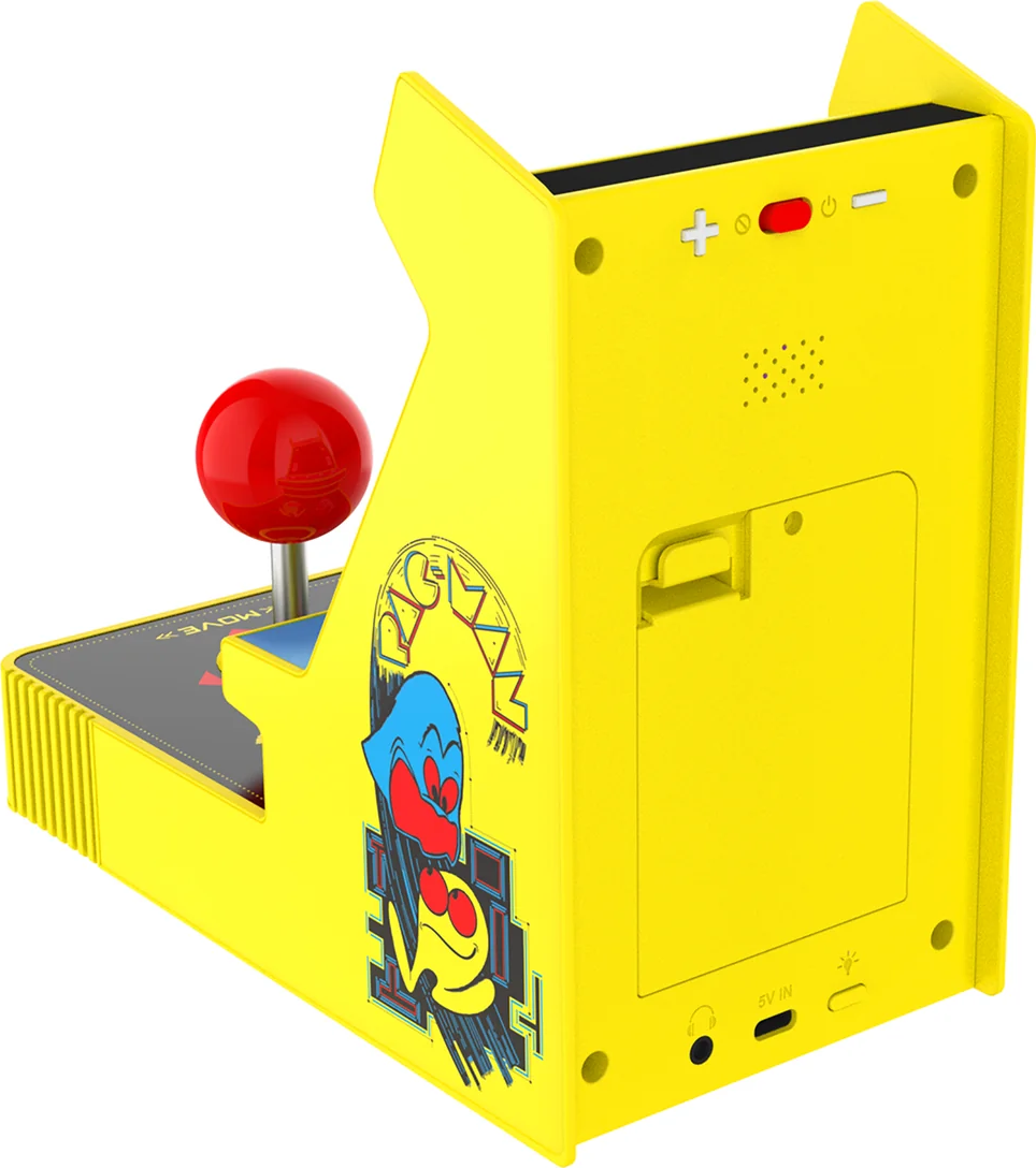 Une borne d'arcade Pac-Man jaune. Elle a un joystick rouge, des graphismes Pac-Man et des boutons à l'arrière. La machine est sur une surface blanche.