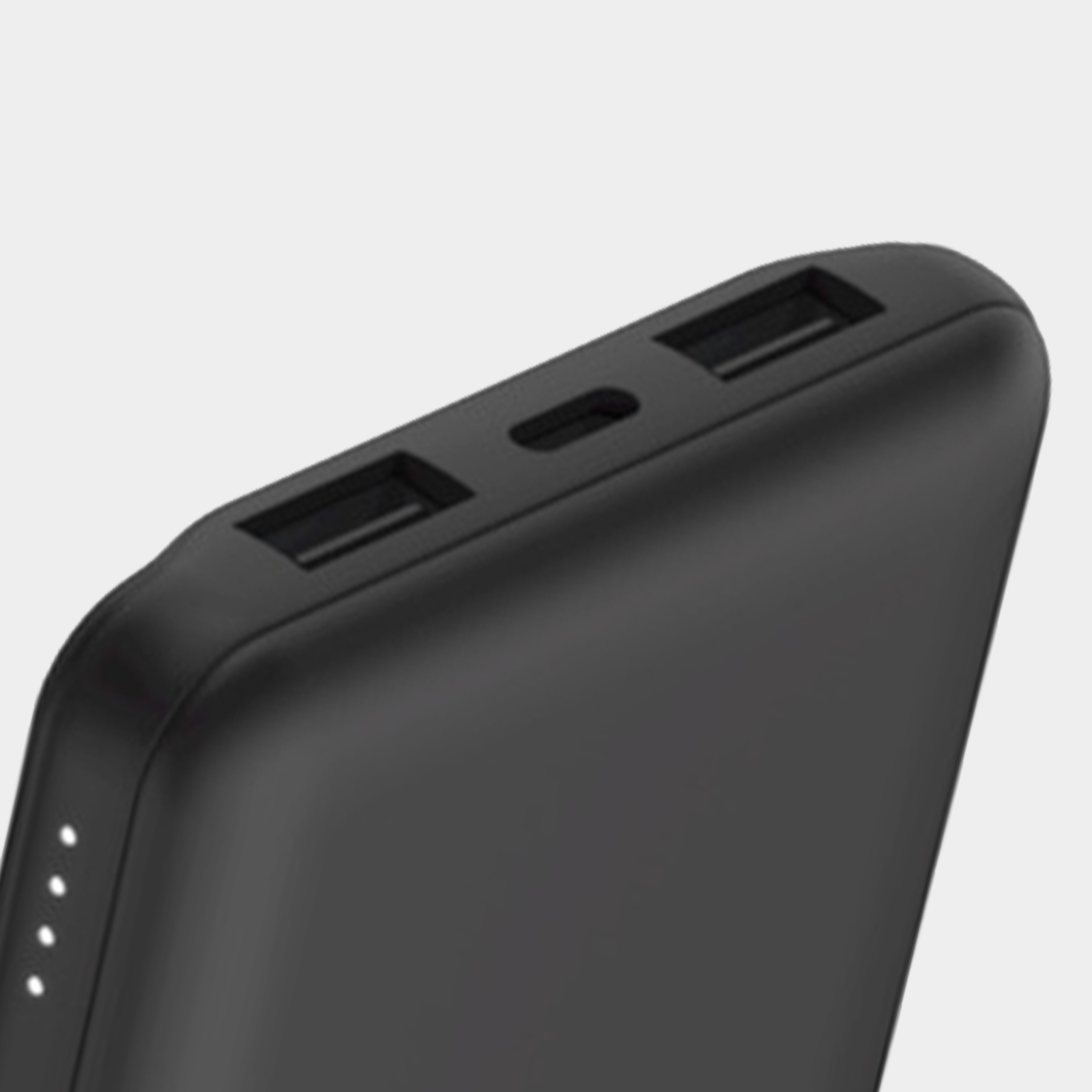 Primer plano de un banco de energía negro. Tiene puertos USB y un puerto de carga, con luces LED blancas.