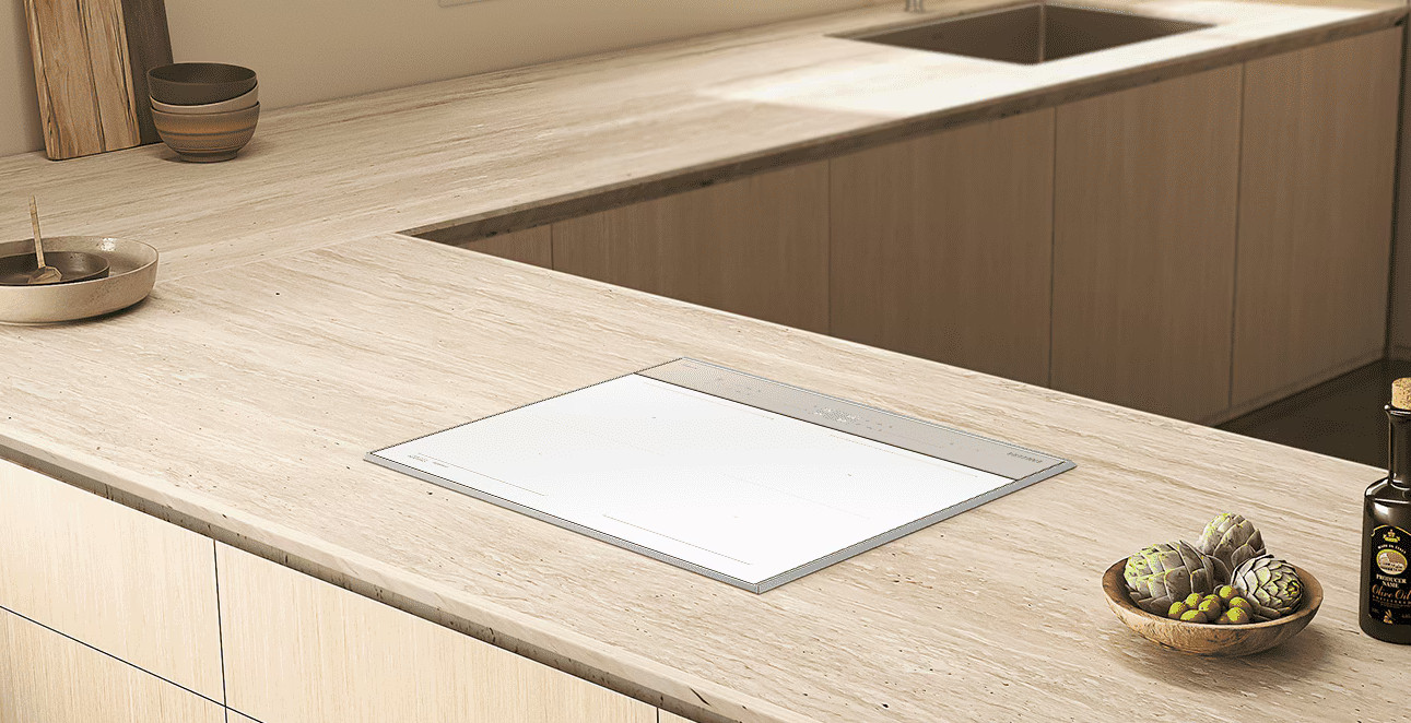 Nowoczesny blat kuchenny z płytą grzejną, miskami, karczochami i oliwą z oliwek.