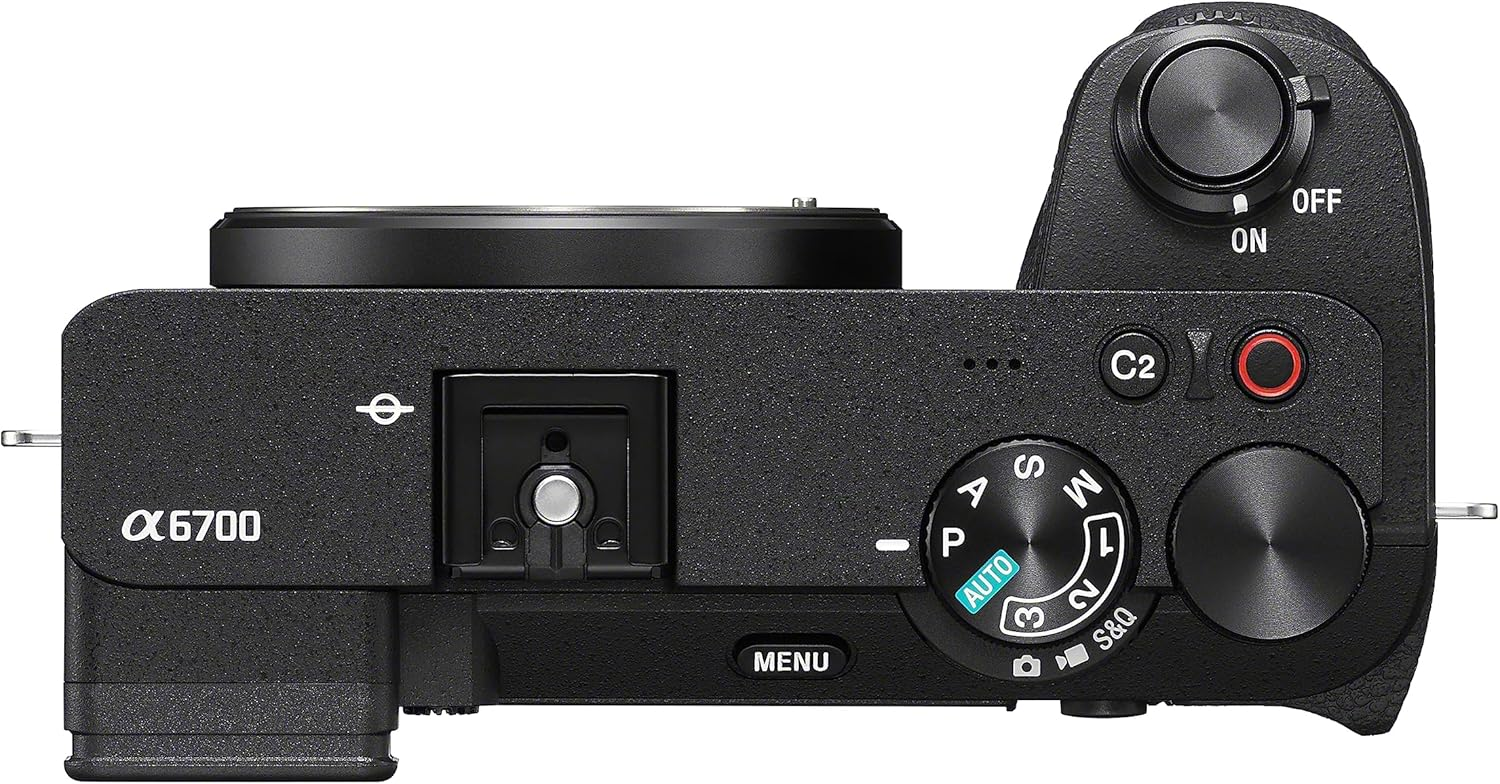 Siyah bir Sony Alpha 6700 kameranın üstten görünümü. Çeşitli kadranları, düğmeleri, bir flaşı ve açma/kapama anahtarı görünür.