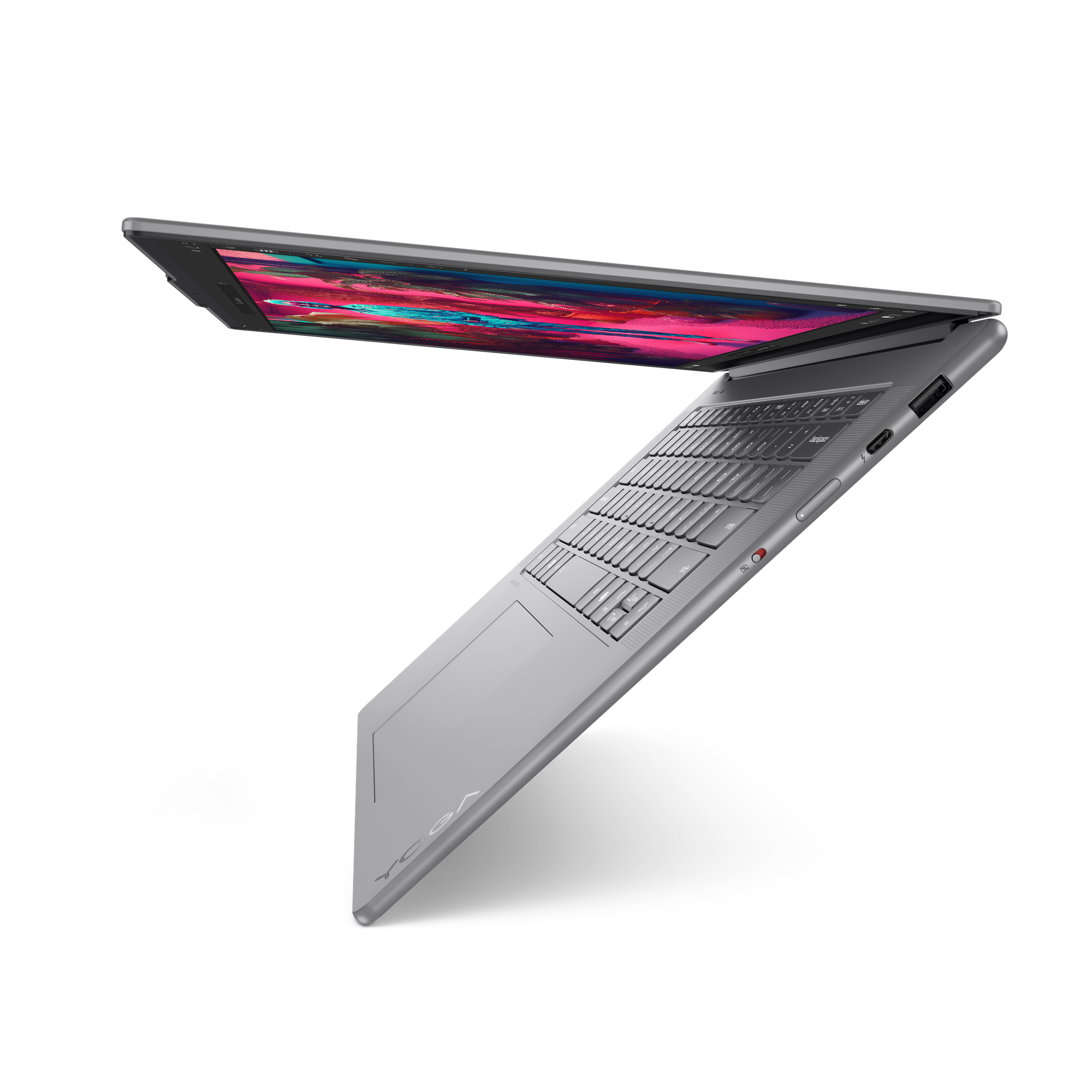 Een zilveren laptop op een zwarte achtergrond is open. Het scherm toont kleurrijke vormen. Het toetsenbord is zichtbaar.