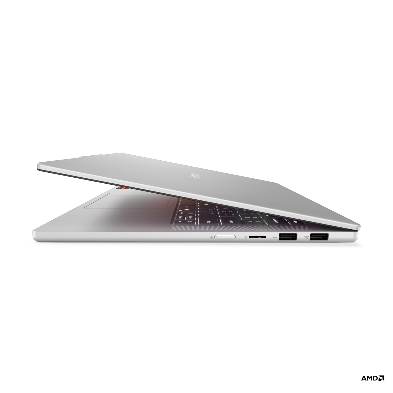 Silver laptop, partially open, side view. Shows keyboard, ports, and AMD logo. The background is white.
