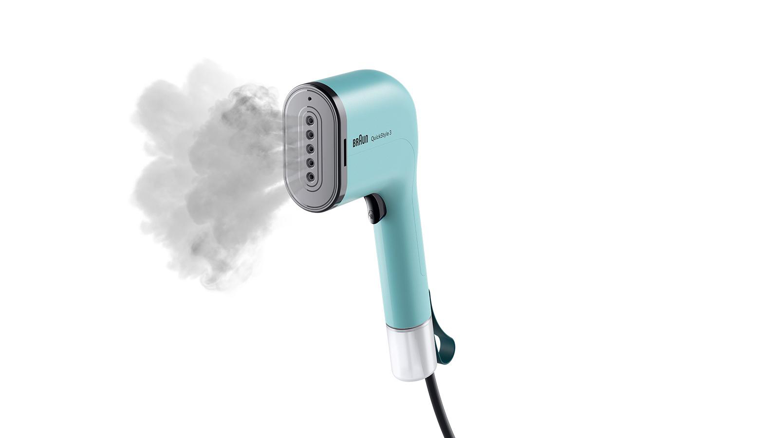 Ein türkisfarbener Braun QuickStyle 3 Steamer stößt Dampf aus. Der Griff und die Düse sind türkis, mit einer silbernen Frontplatte.