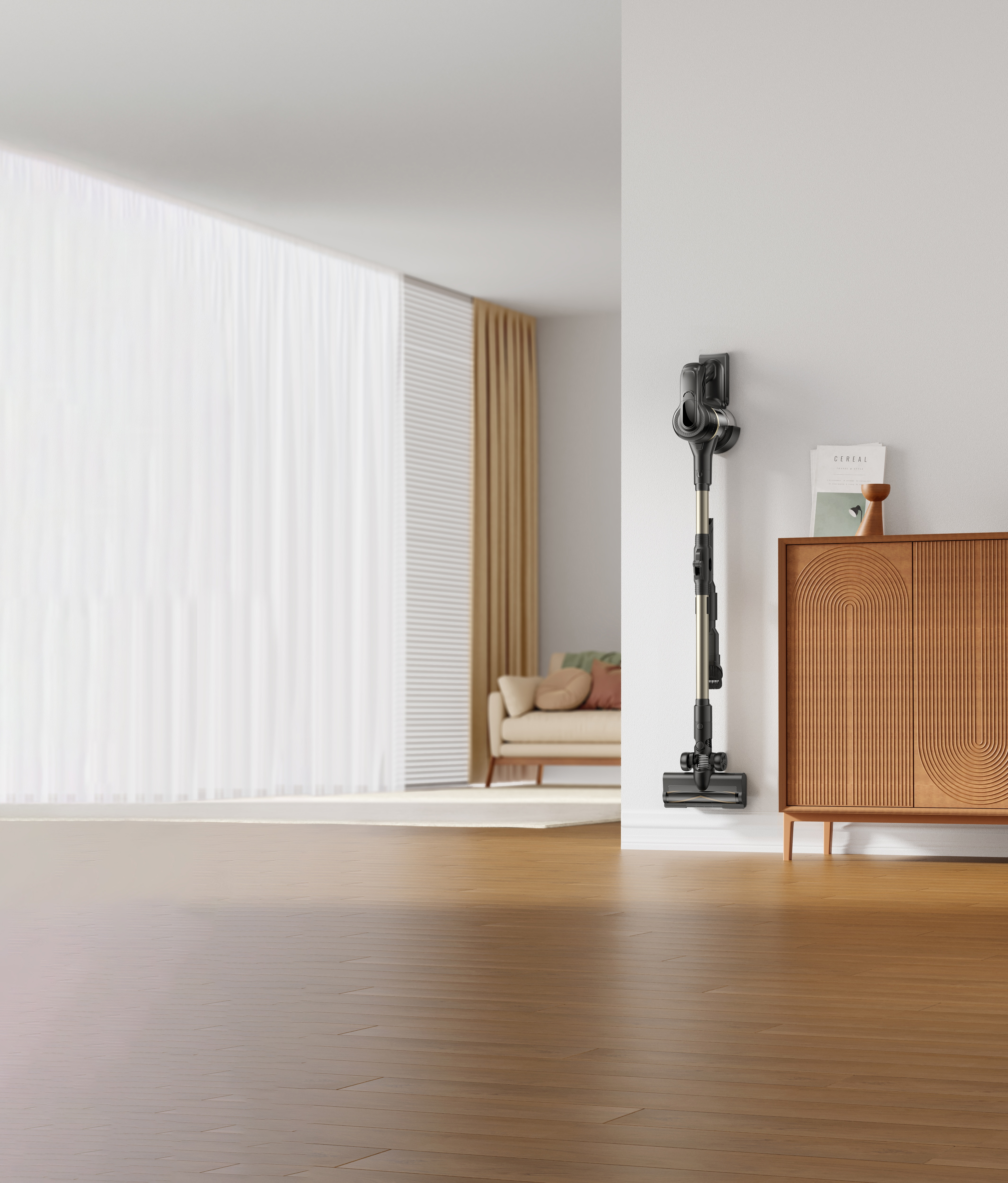 Bezprzewodowy odkurzacz jest zamontowany na białej ścianie. Po prawej stronie znajduje się drewniana szafka, a w tle sofa.