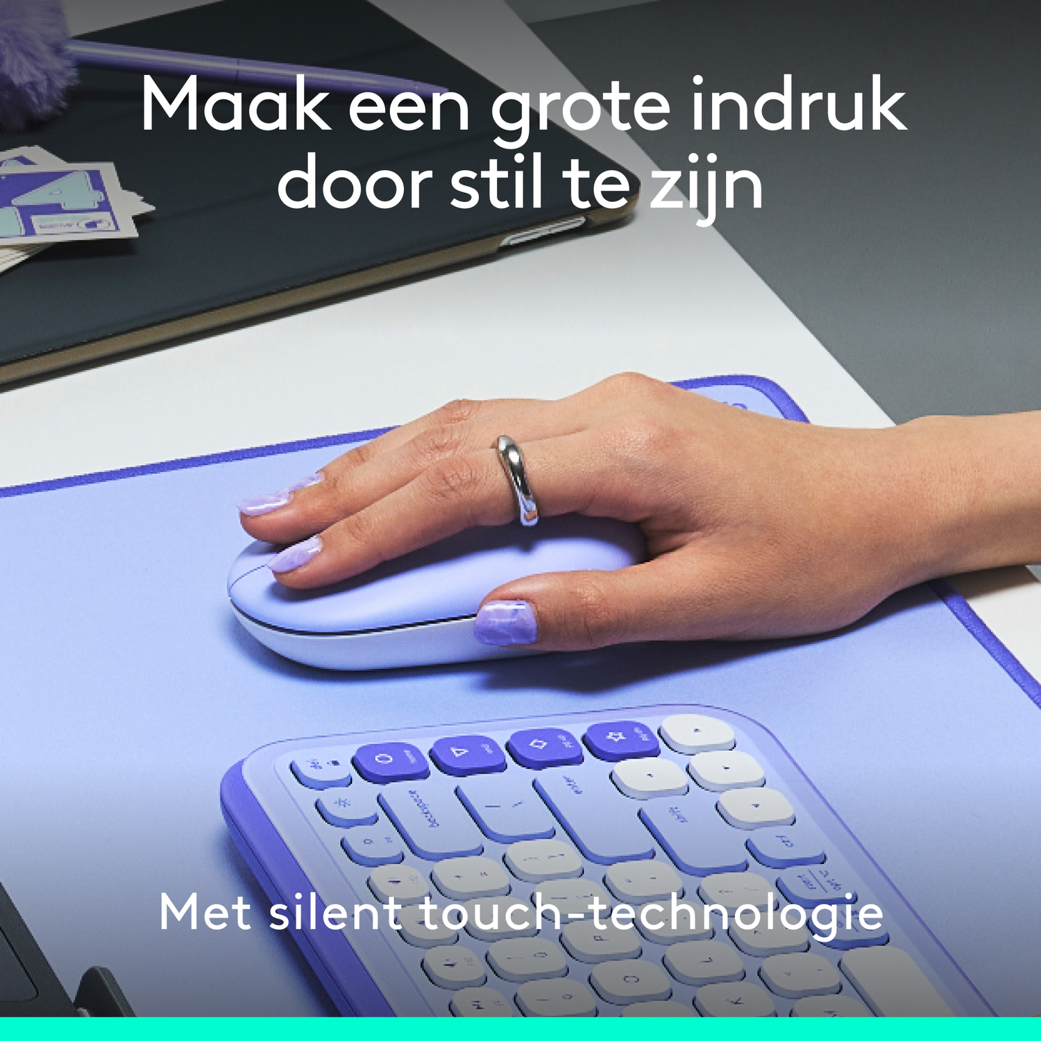 Hand with ring on a mouse, keyboard in the foreground. Purple theme. Text: Make a big impression by being quiet. With silent touch technology.